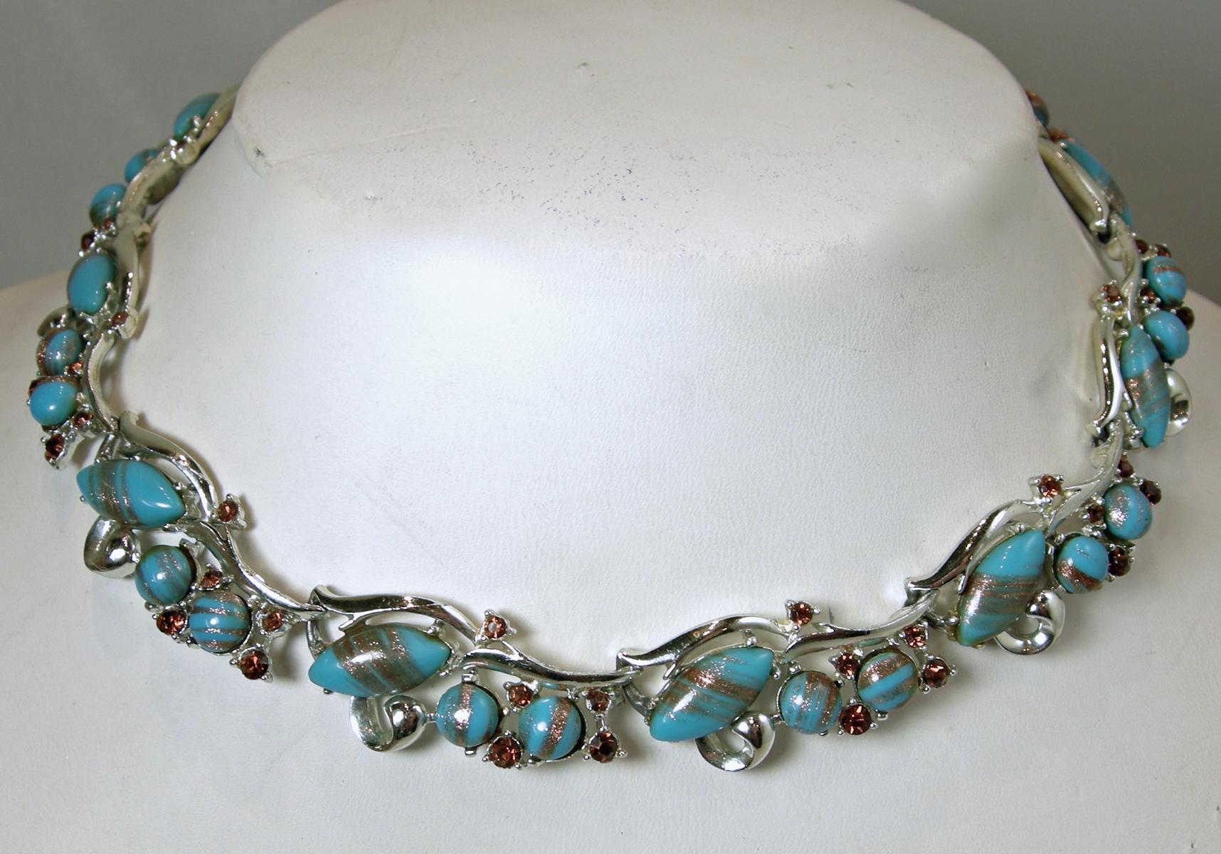 This vintage Murano glass necklace & earrings set integrates the color turquoise with topaz crystal accents in a silver tone setting.  The necklace measures 16” x 5/8” with a hook clasp. The matching clip earrings are 1-1/8” x 1”.