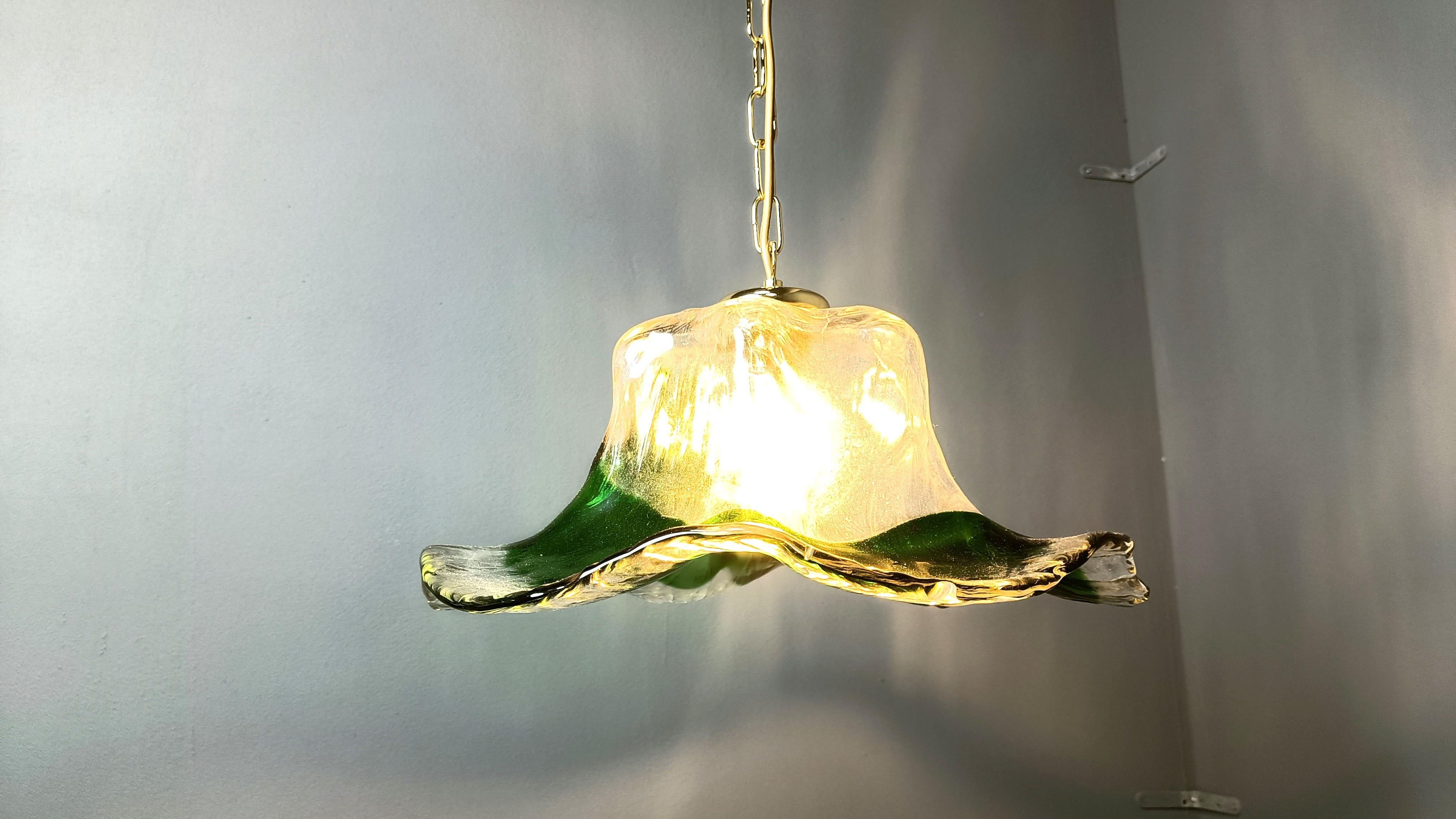 Lampada a sospensione vintage in vetro di Murano verde con supporto per paralume e catena in ottone.

Bellissima cupola in vetro realizzata a mano che emette una splendida luce diffusa.

anni '60 - Italia

Testato e funzionante con una normale