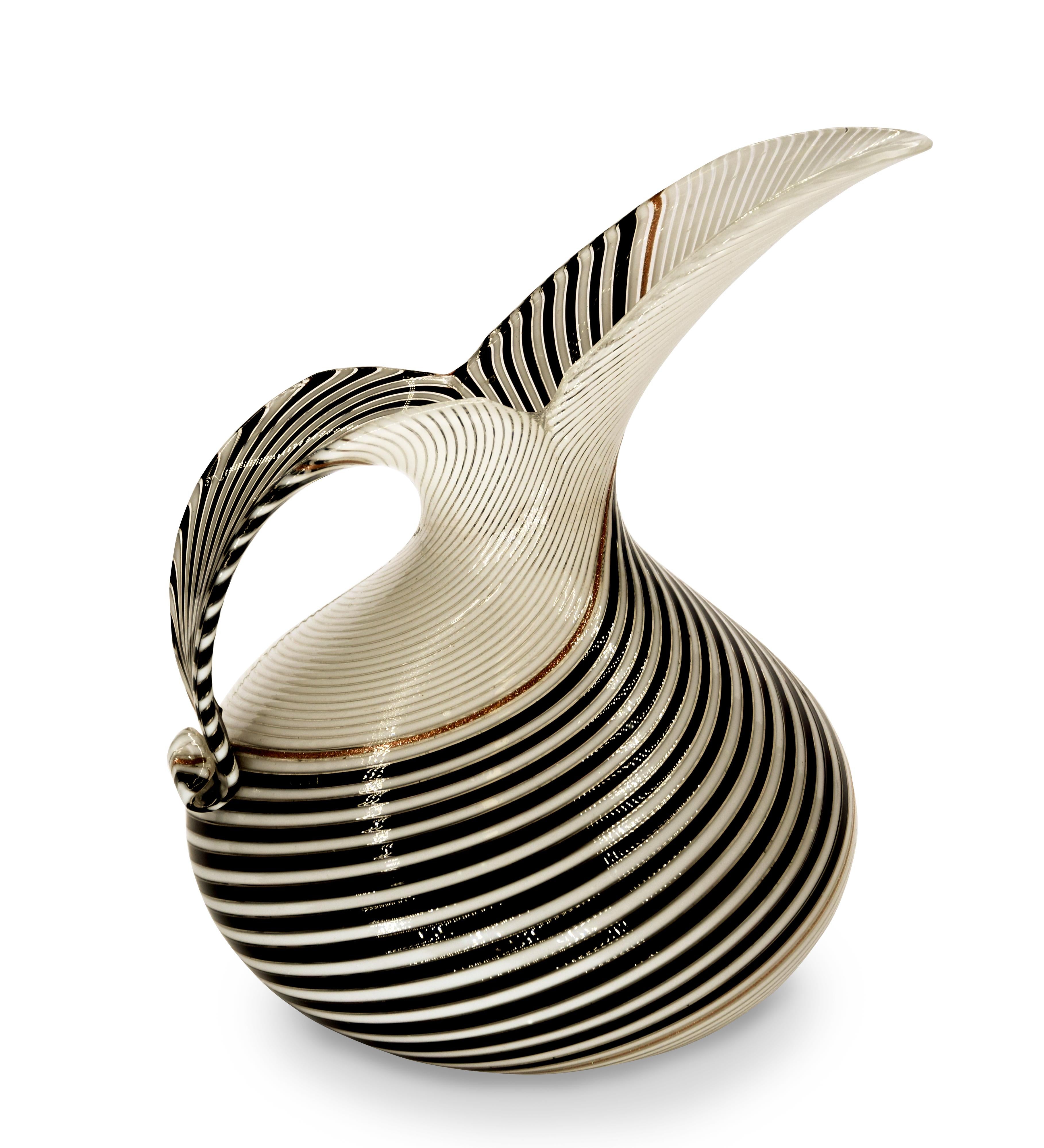 This Pitcher for Aureliano Toso, realized in blown a canne glass in 1950s, is designed by Dino Martes (1894-1970).

In excellent conditions, with an elegant shape and strong contrasting colors.

This object is shipped from Italy. Under existing