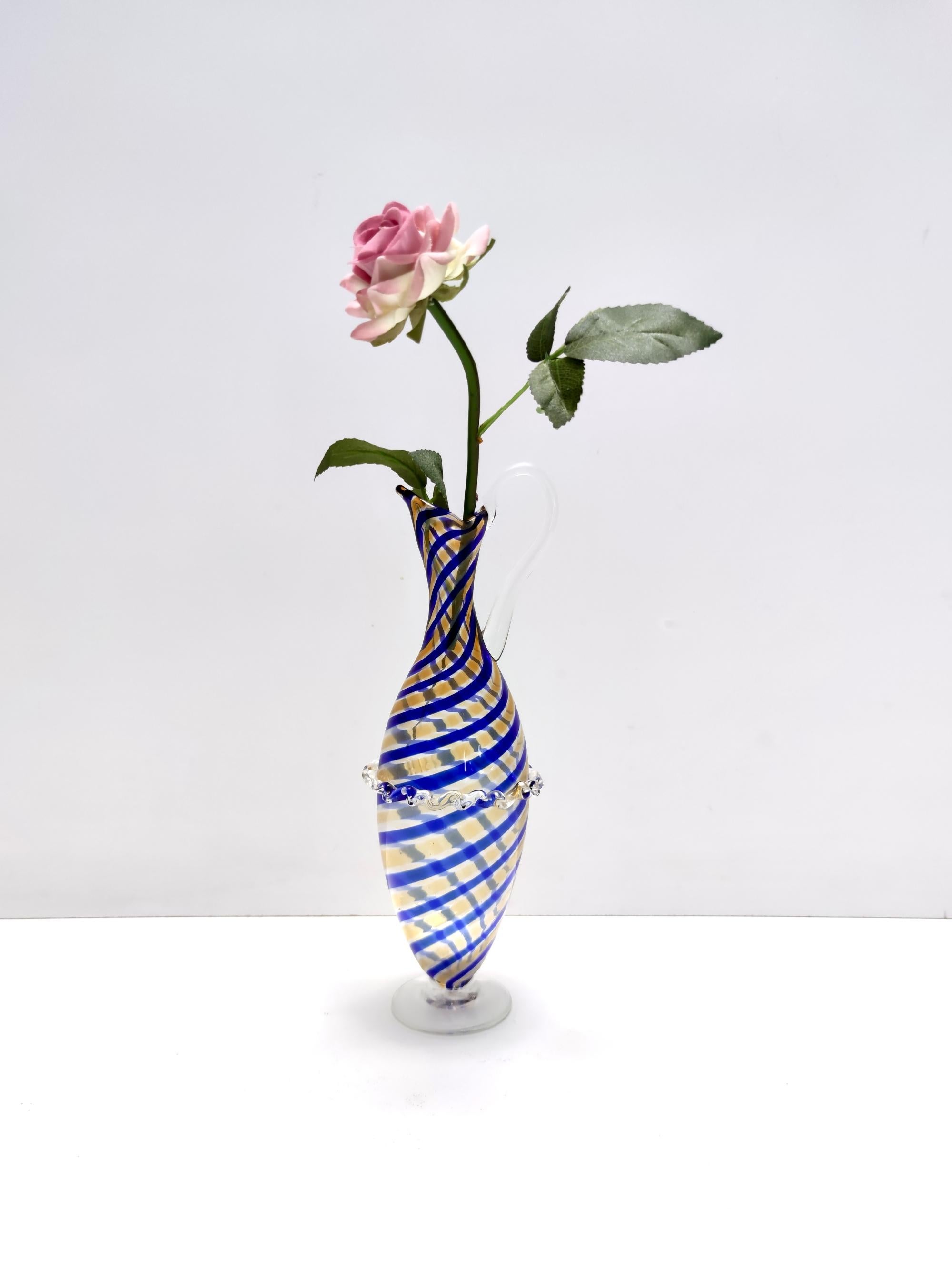Made in Italy, 1940s - 1950s.
This pitcher vase is made in Murano glass and features royal blue and yellow canes and a transparent base and handle.
It is a vintage item, therefore it might show slight traces of use, but it can be considered as in