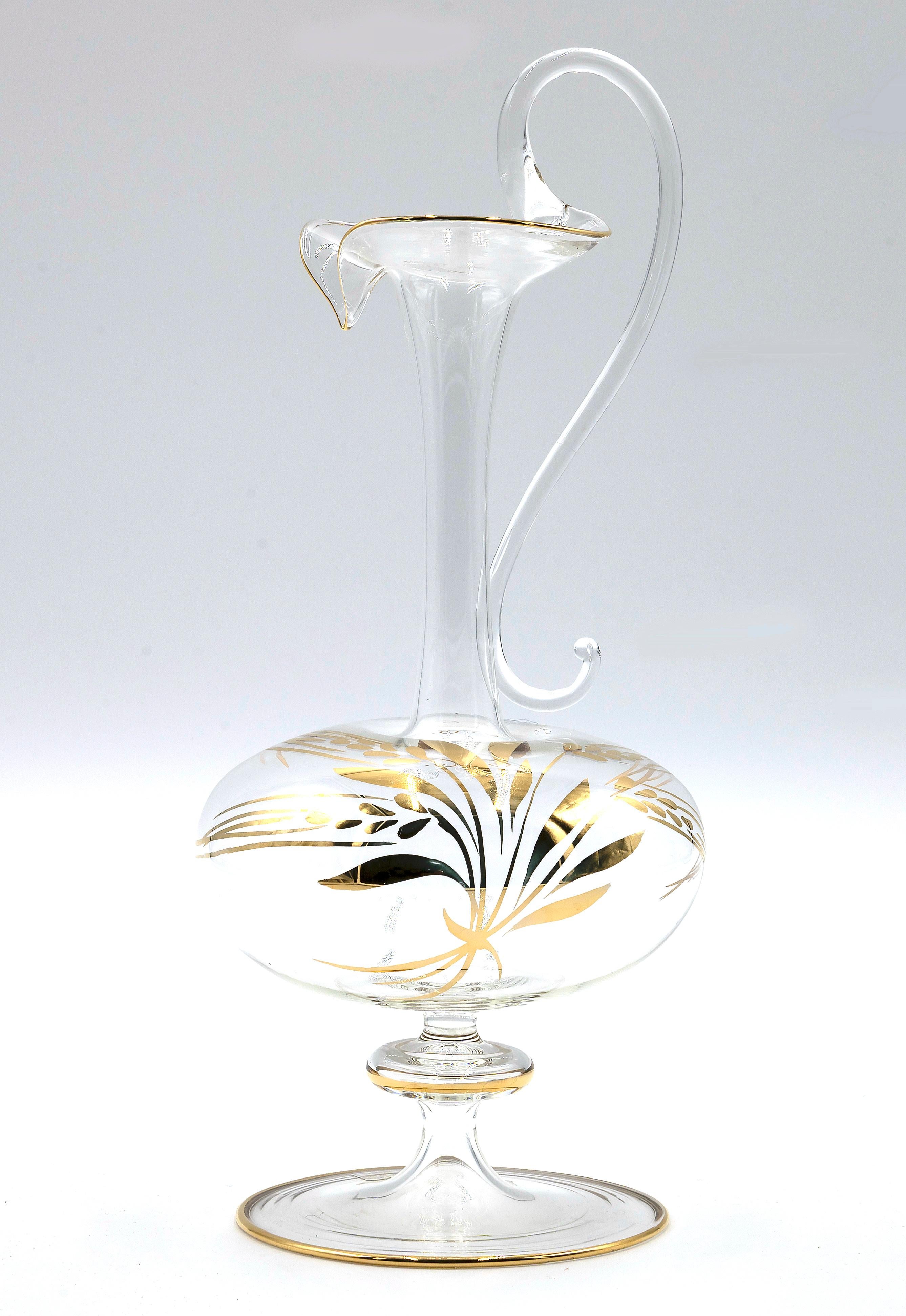 Le pichet en verre est un merveilleux objet décoratif en verre, réalisé dans les années 1970 par les maîtres de Murano en utilisant de l'or pur. 

Très beau pichet en verre transparent avec anse et avec des décorations de feuilles