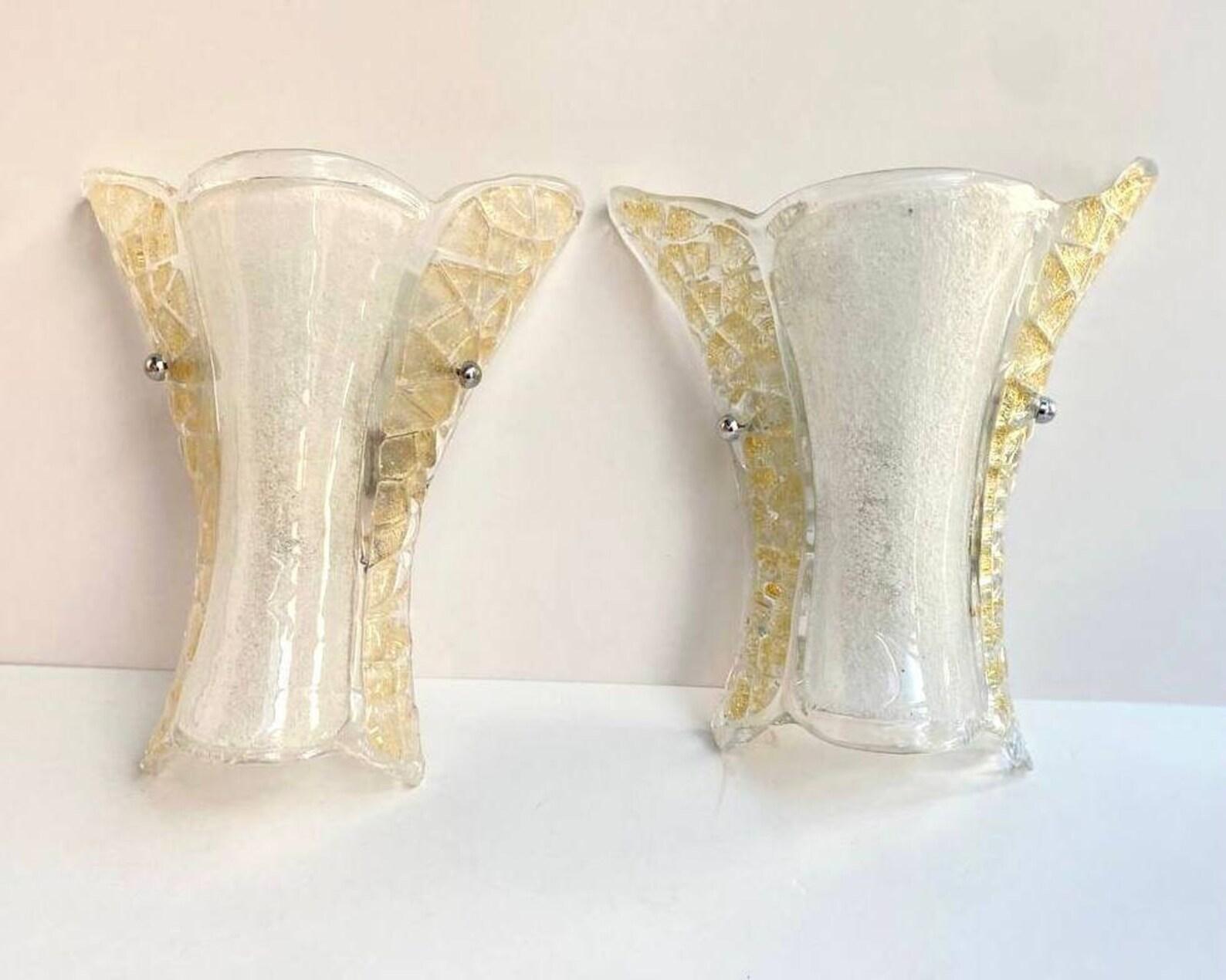 A pair of wall lamps with conical shades made of Murano glass from Venini. 

 Italy, 1970s. 

 Plate-worked clear glass diffuser with white glass granules in the middle and amber ones on the sides. Chrome glass holders.

 An unusual model from