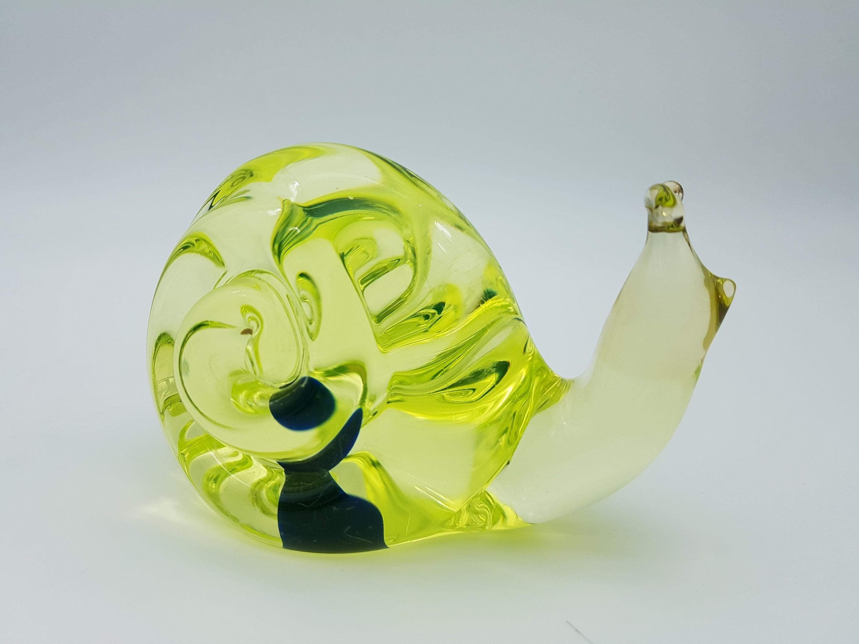 This cute vintage snail was made in the mid-1960s in Murano by the glass-factory Gino Cenedese e Figlio and desigend by Antonio da Ros. The seal is made in vaseline yellow glass, with a inner blue bubble, and is detailed with two upper tentacles.