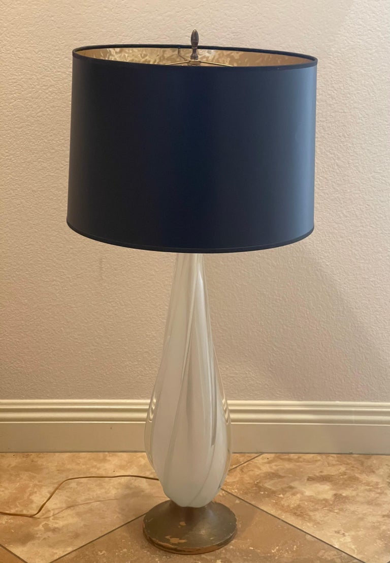 Stunning Murano glass sommerso table lamp, circa 1950s. White and clear art glass are swirled in a free form style to form the base of this gorgeous lamp, which sits on a gold leaf wood base. The addition of a large black drum shade makes this piece