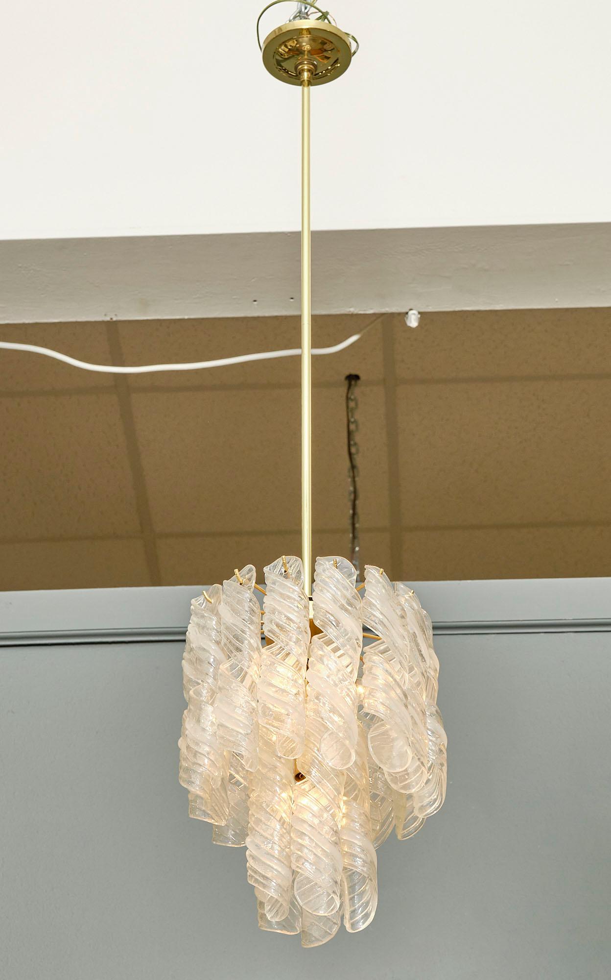 Chandelier from the island of Murano featuring an array of “torcilioni” clear glass hanging from a two level brass structure.
The current height from ceiling is 51
