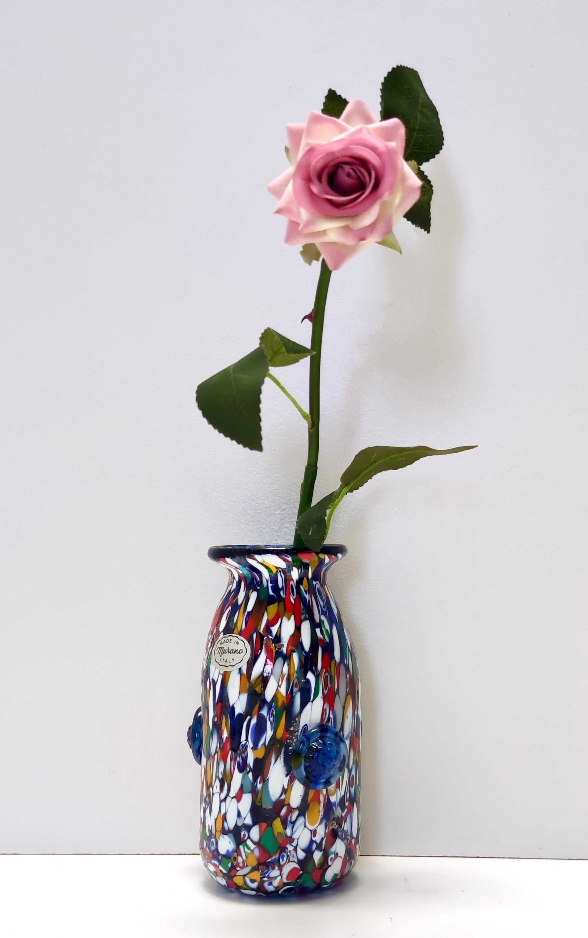 Made in Murano, Italy, 1960s. 
This is a Murano glass multi-colored vase, that is highly ascribable to Fratelli Toso's millefiori.
It has a multitude of different murrines, in a rainbow of colors.
This vase is a vintage item, therefore it might show