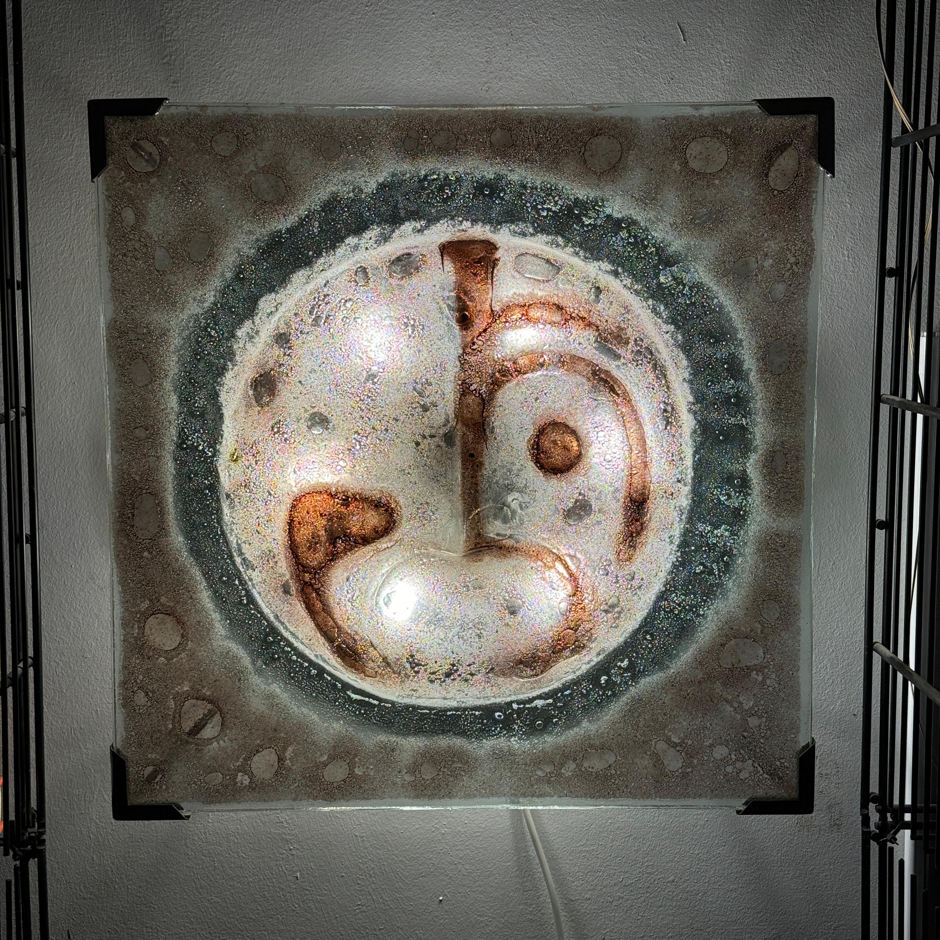 The Vintage Murano Glass Wall Lamp from Italy, crafted in the 1970s, is an exquisite piece of art that effortlessly combines function with aesthetics. This unique wall lamp, shaped to represent a face, embodies the artistry and craftsmanship that