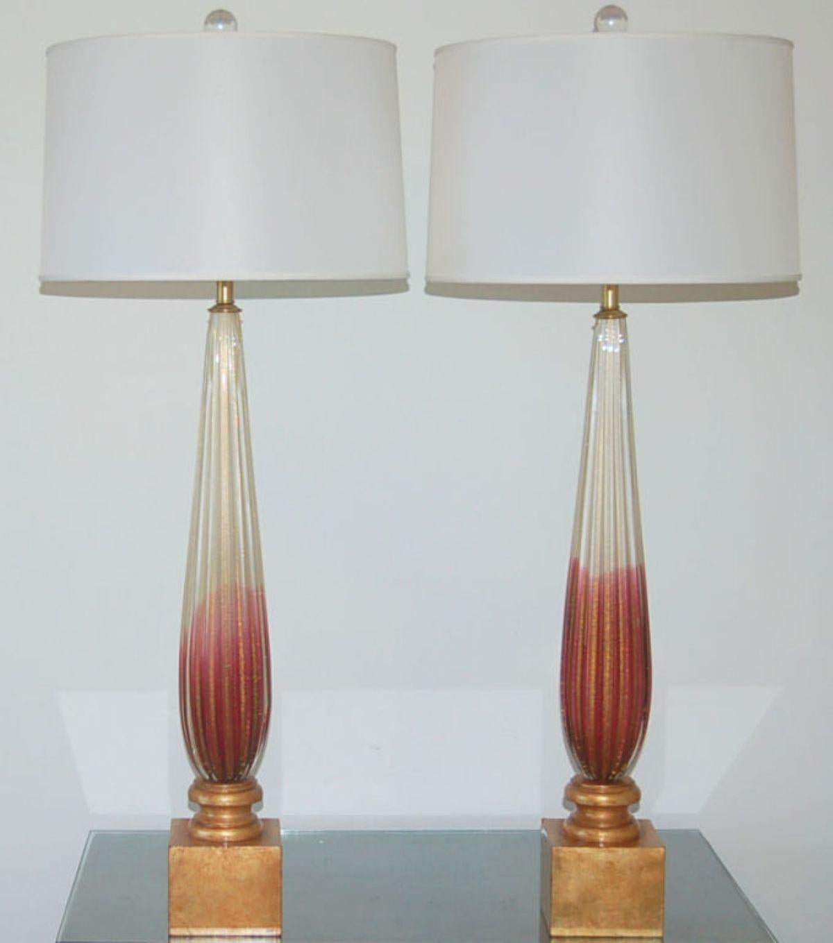 Stunning pair of vintage Murano lamps in CRANBERRY and CREAM. Very rare and unique color pattern with loads of 24kt gold dust blown into the glass. These will dazzle in the light!

Lamps measure 30 inches from tabletop to socket top. As shown, the