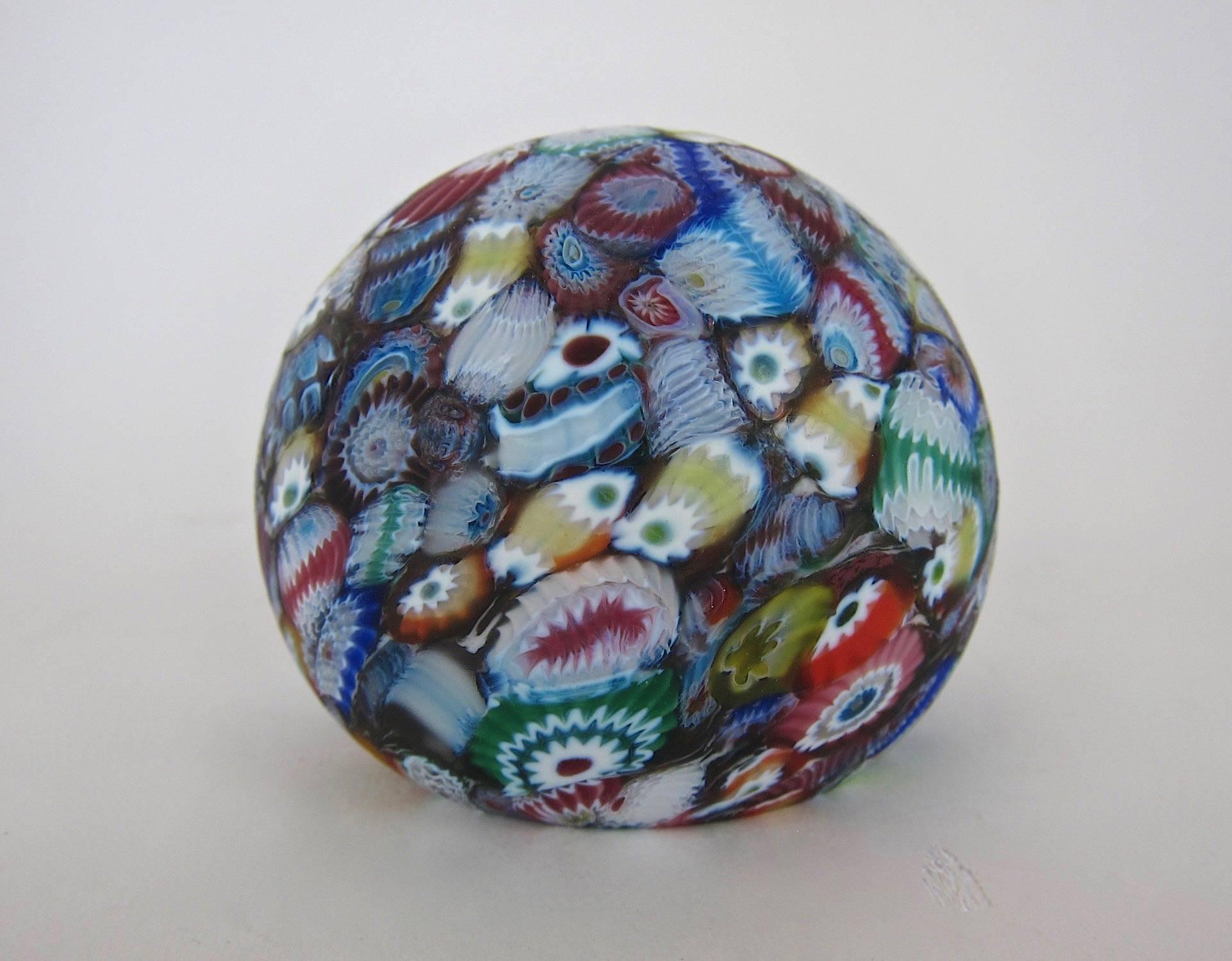 A vintage Murano art glass crown paperweight, handcrafted with multicolored millefiori (murrine) canes in a scattered or end-of-day design against a dark ground. The solid glass weight has a satin matte finish and is unmarked but likely by Fratelli