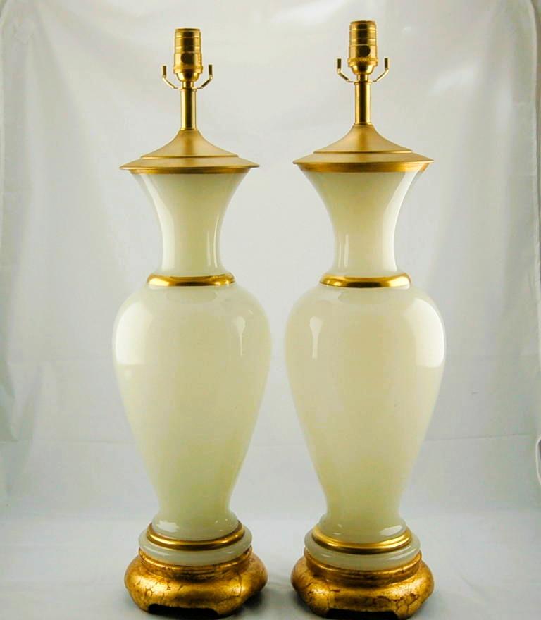 Lampade da tavolo in vetro francese vintage in White Opaline. Il bagliore etereo del vetro è merito dell'Opalina. Il colore WHITE MIST ha un leggero accenno di PALE YELLOW, bordato da bande d'oro dipinte a mano.

Si ergono per 30 pollici dal piano