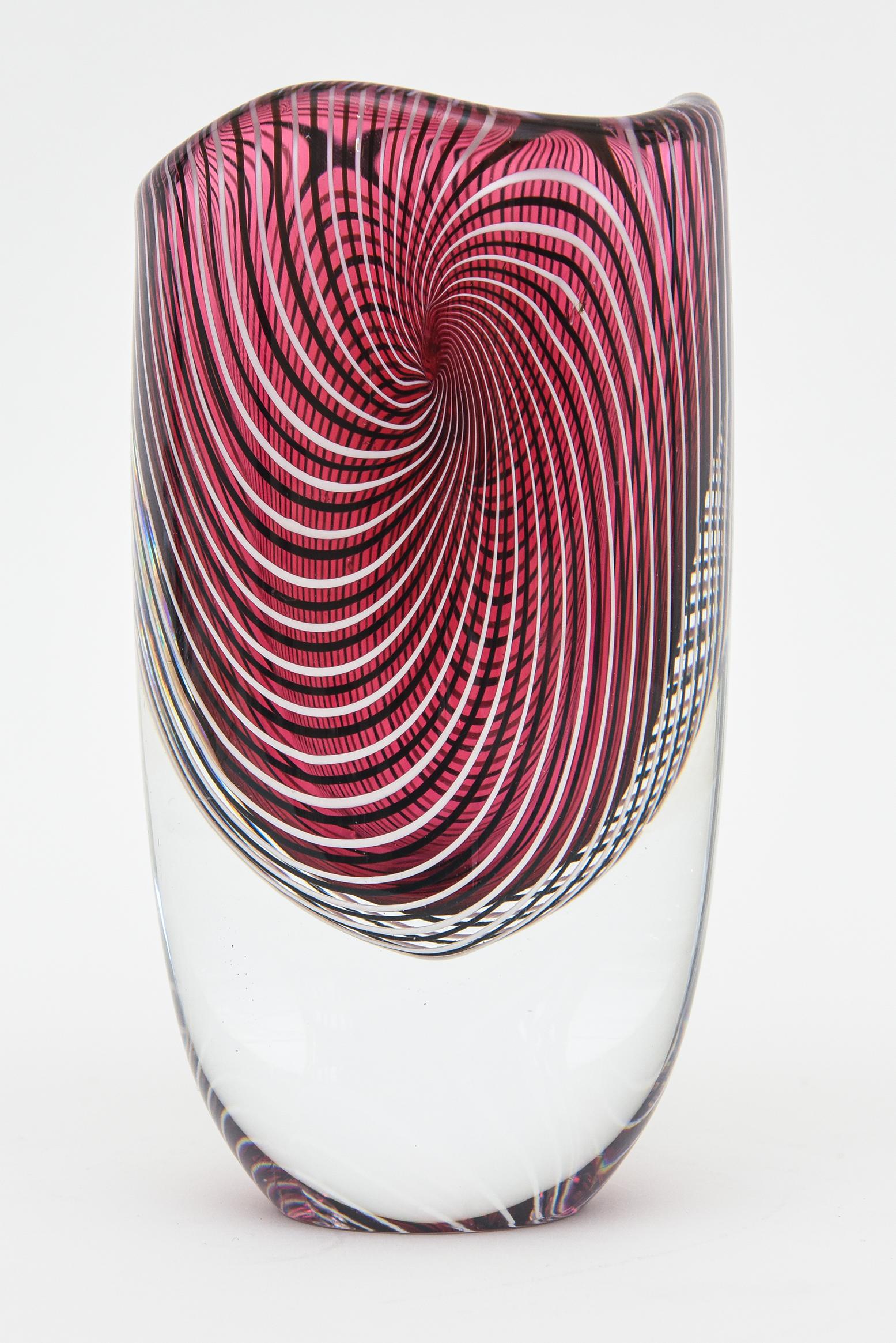 Diese faszinierend schöne Vintage-Vase aus Murano von Seguso Viro hat ein großes Gewicht und ist von einem spiralförmigen Muster aus durchgehenden Streifen umgeben. Das Oberteil hat einen leichten Wellenschliff.
Das originale Label ist intakt und