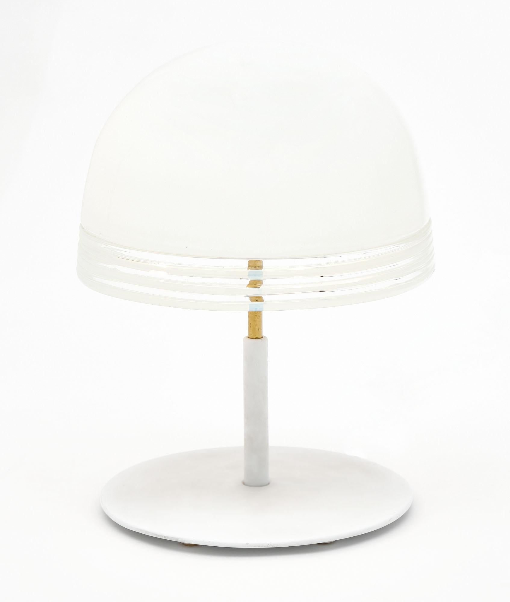 Lamp from Murano, Italy. This lamp presents a white lacquered base holding a brass stem supporting a white opalescent glass shade. It has been newly wired to fit US standards.