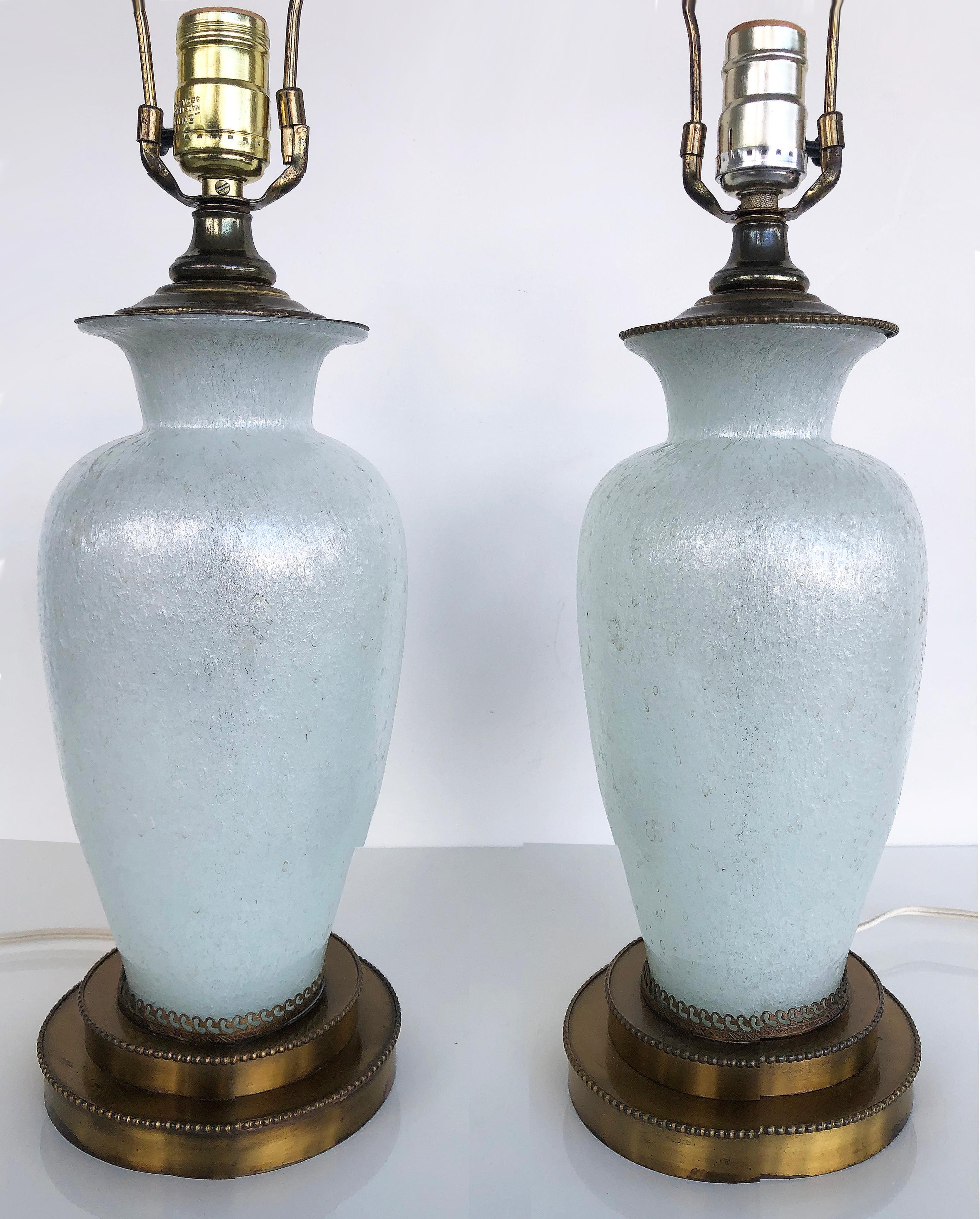 Vintage Murano textured pearlized glass table lamps, Pair

Offered for sale is a pair of vintage Murano glass table lamps with a pearlized and textured finish. They are wired and in working condition. The sockets accommodate a standard bulb. Harps