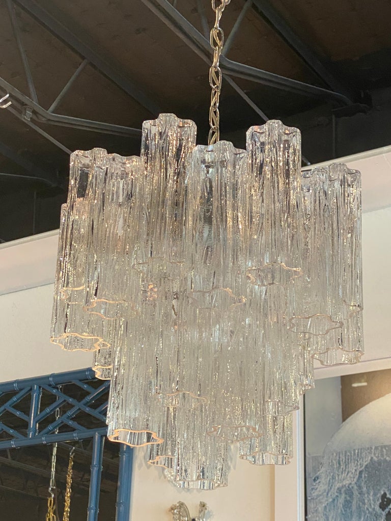 Lovely vintage Murano Tronchi Italian glass chandelier. No chips or breaks to any glass. May be patina to the chrome chandelier cage. Tested and working. Holds 4 lights. 25 glass pieces. Since chain is adjustable, size below is actual chandelier