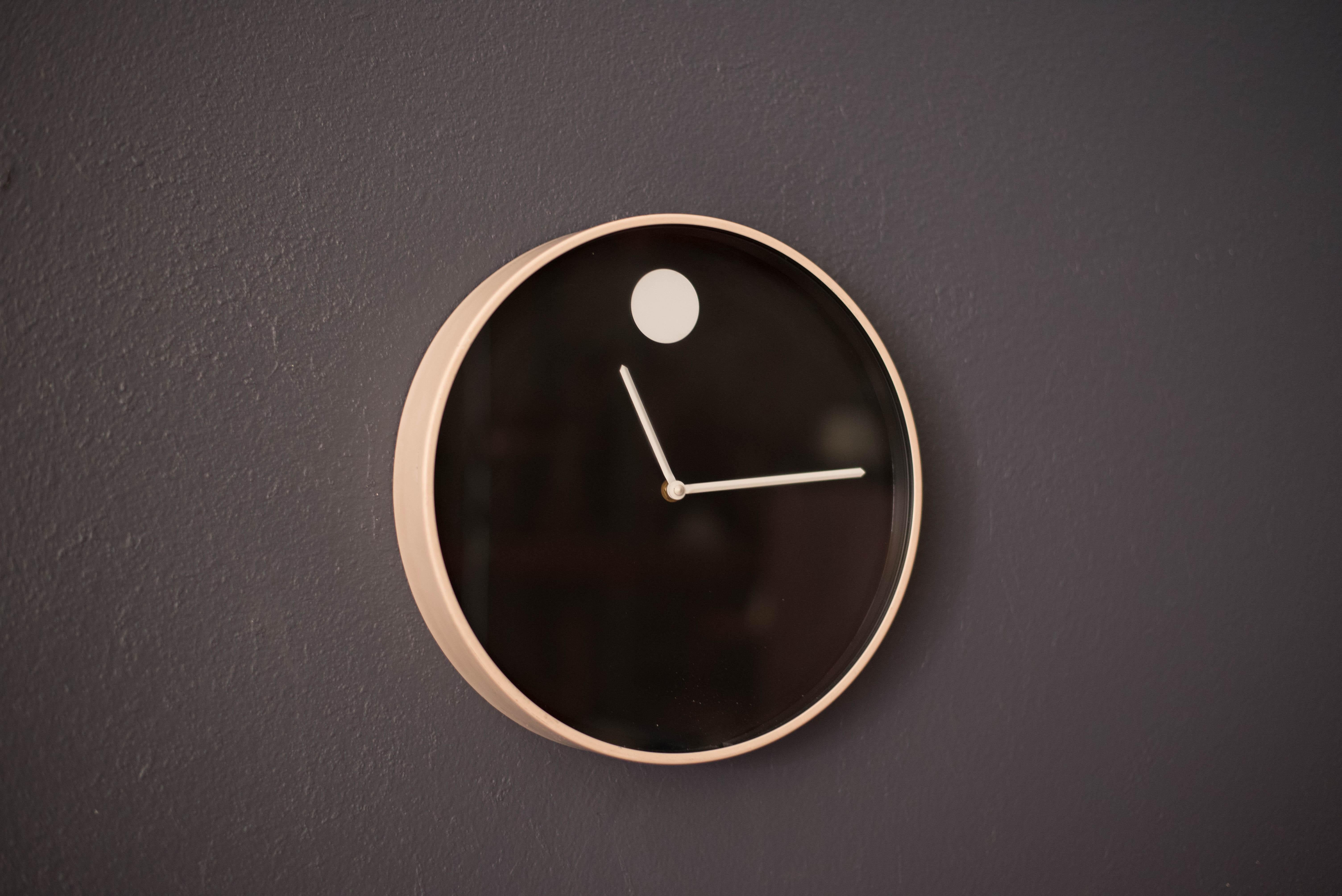Moderne Museumswanduhr aus der Jahrhundertmitte, entworfen von Nathan George Horwitt für Howard Miller Clock Company, Zeeland Michigan. Das Gehäuse ist mit einer Eierschalen-Emaillierung und einer markanten schwarzen Frontplatte mit Glasschutz