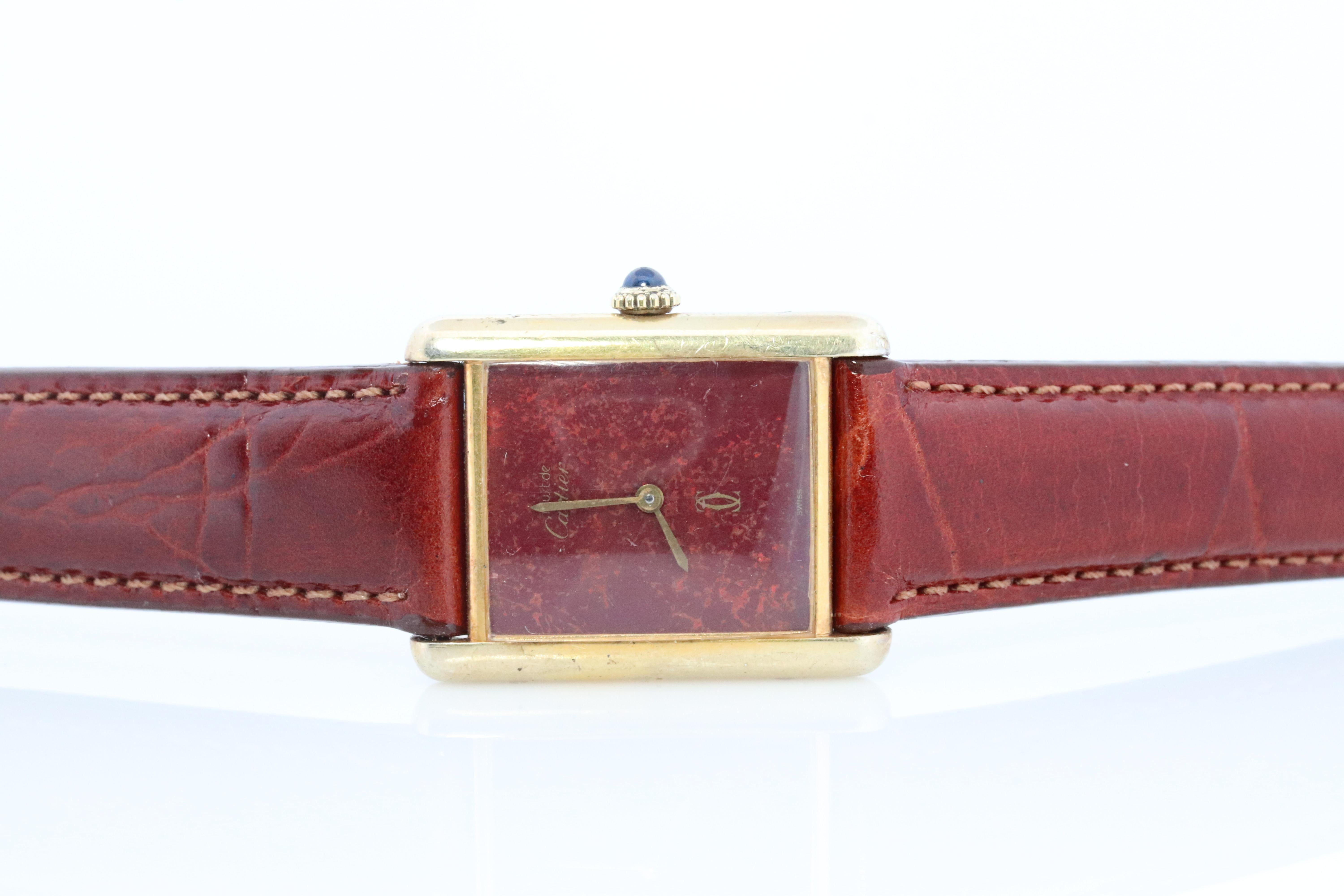 Genuine Cartier watch. Vintage Iconic Tank Argent. Sterling Silver and 18k Gold plated (Vermeil). 

Marble Brown Maroon Dial. 

Manual Windup Movement.

Condition: Has some discoloration on the sides that is consistent with age. Winds up well,