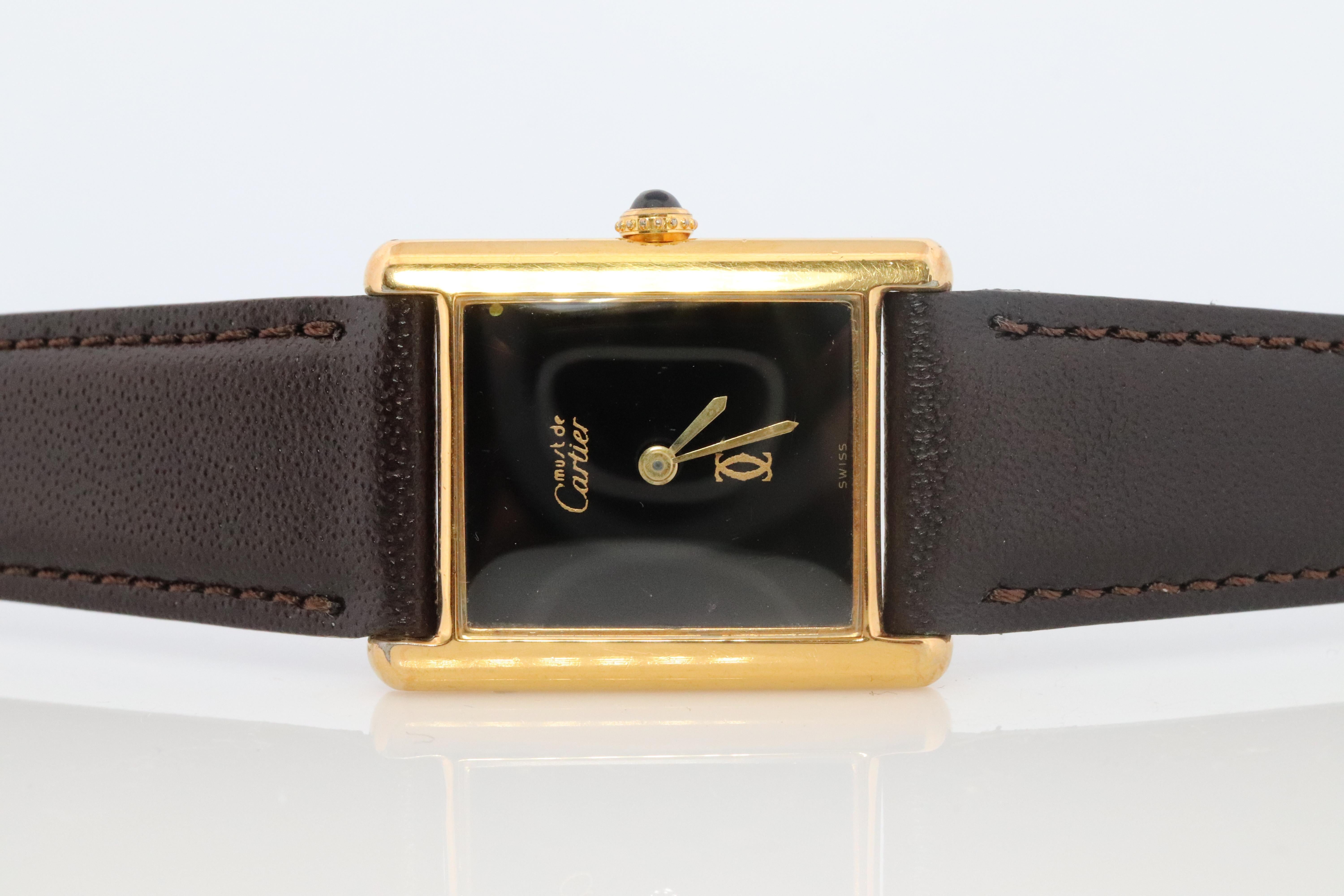 Genuine Cartier watch. Vintage Iconic Tank Argent. Sterling Silver and Gold plated (Vermeil).

Rare Black Mystery Dial with Windup Manual Movement.
ref 7007873

Condition: Has some discoloration on the sides that is consistent with age. Winds up and