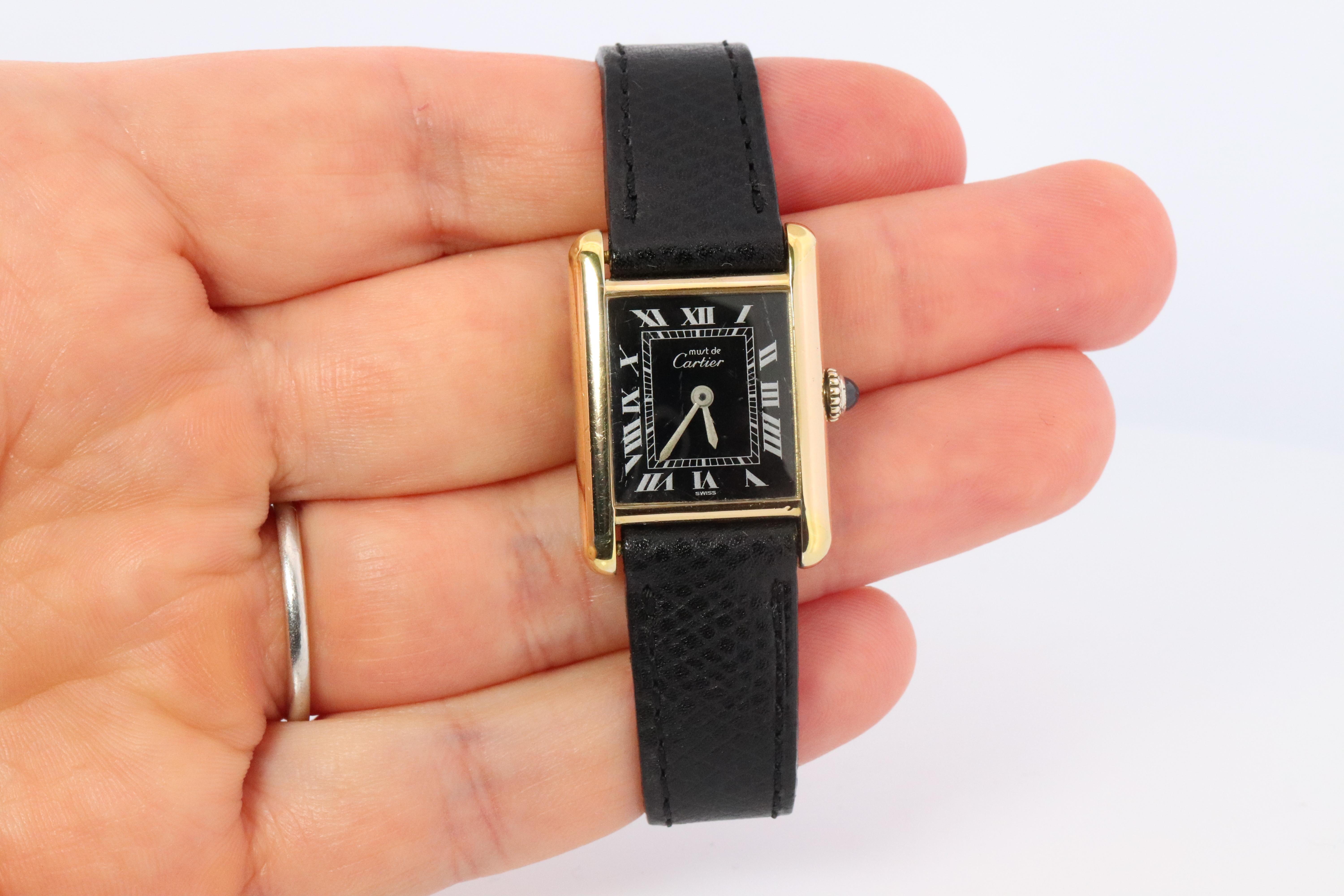 Genuine Cartier watch. Vintage Iconic Tank Argent. Sterling Silver and 18k Gold plated (Vermeil).

Ref 3055582

RARE Black Roman Dial.

New Gucci Leather Band.

Manual Windup Movement.

Details:
21mm by 28mm Case


Please ask for more details,