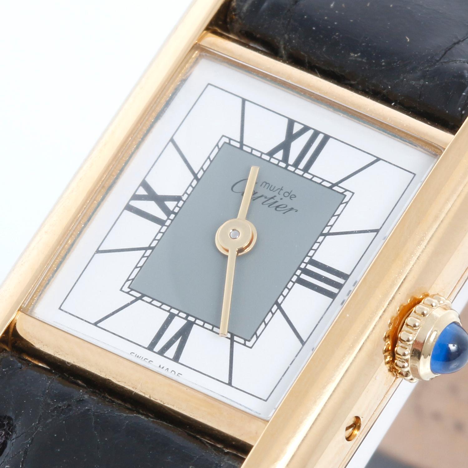 Must de Cartier Tank Vermeil Plaque Quartz Watch - Quartz movement. 18k yellow gold plated sterling silver (22mm x 28mm). Tuxedo two tone Roman numeral dial. Black strap with Gold plated buckle. Replacement strap. New old stock with custom box.