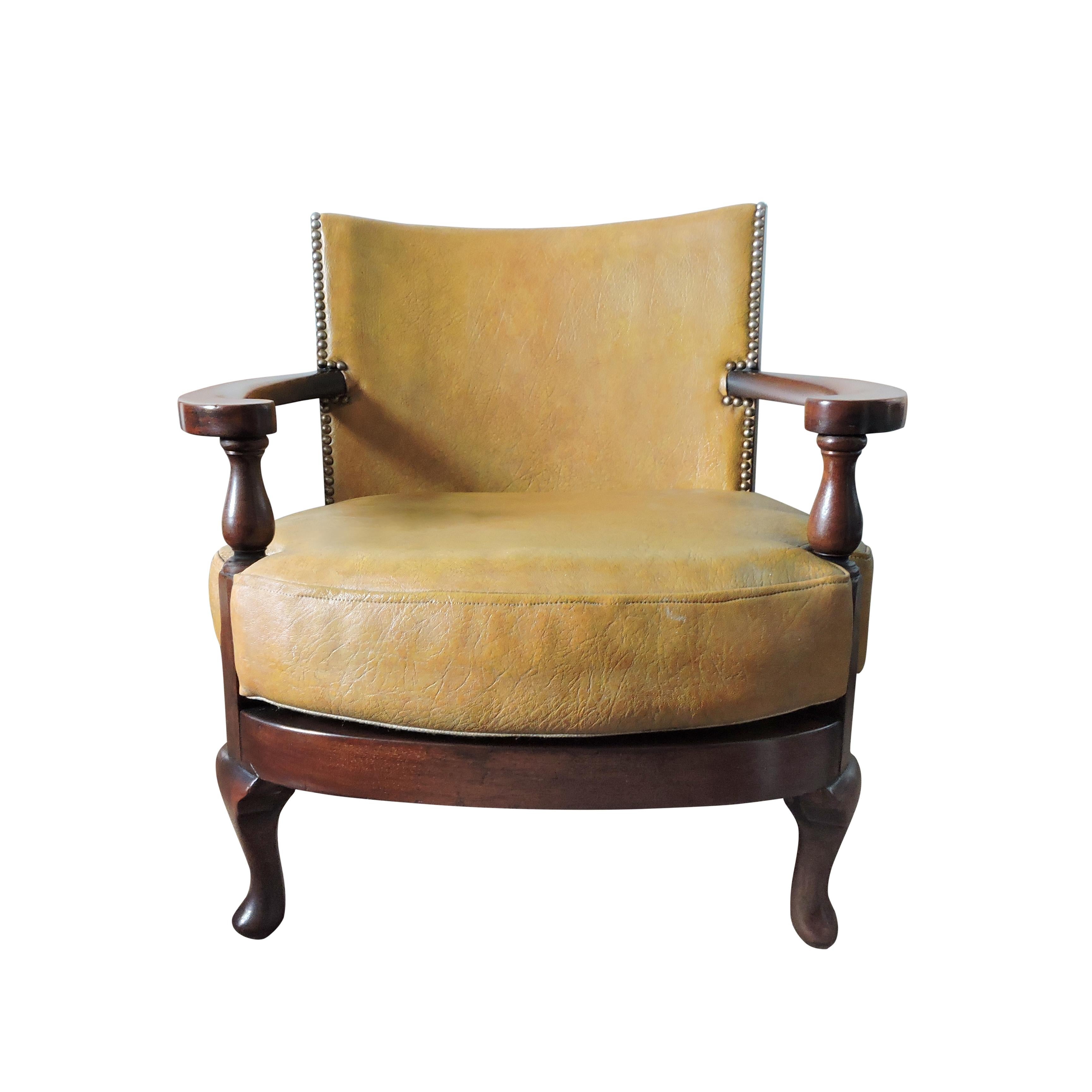 This early 20th century tub chair is made from leather and wood.