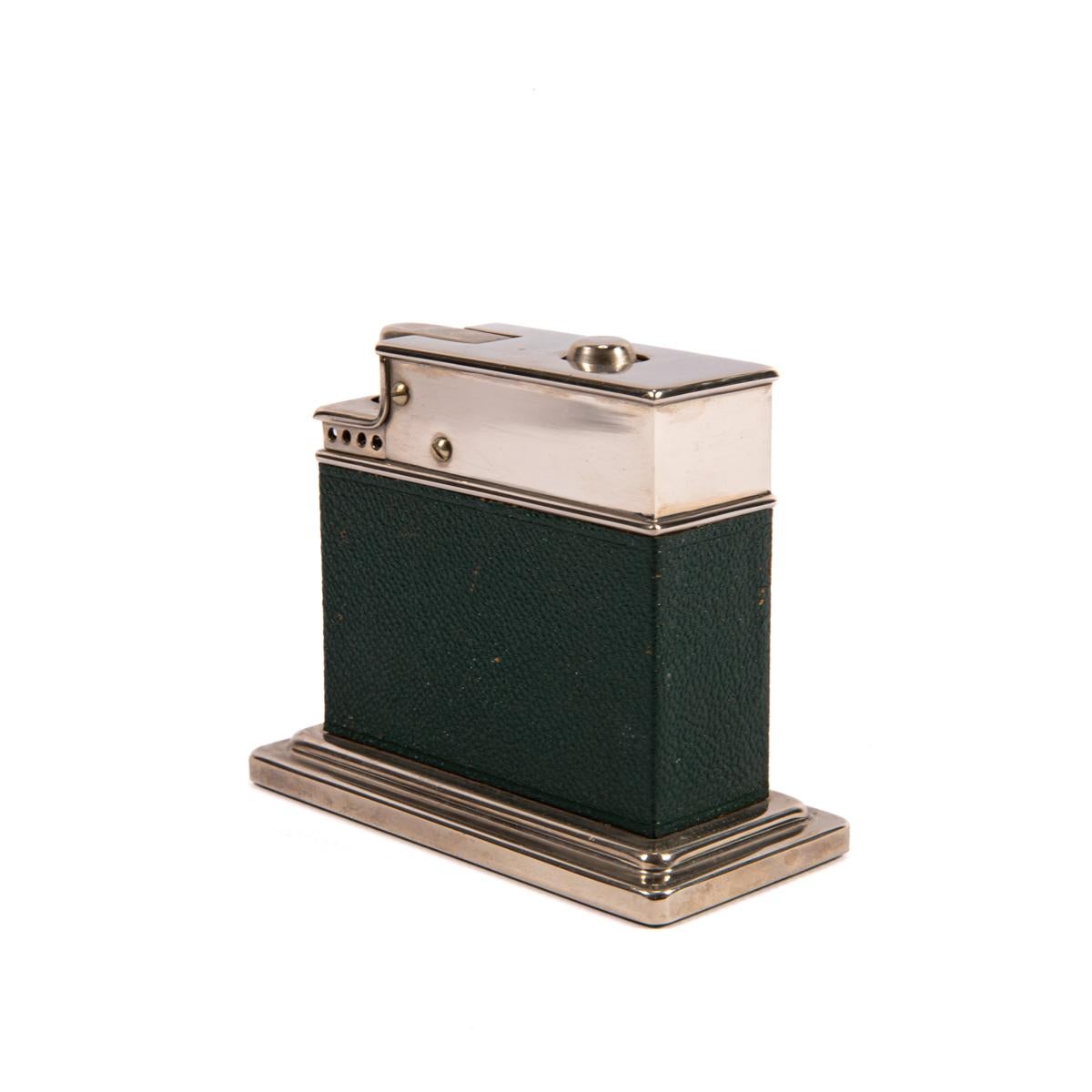 Vintage Myflam Leder Tischfeuerzeug Quadratische Basis

Diese Myflam Tischfeuerzeug ist in einem sehr guten Zustand für sein Alter. Hergestellt in Deutschland in den 1950er Jahren. Fast keine Abnutzung an den Ecken und Kanten, und die Farbe auf der