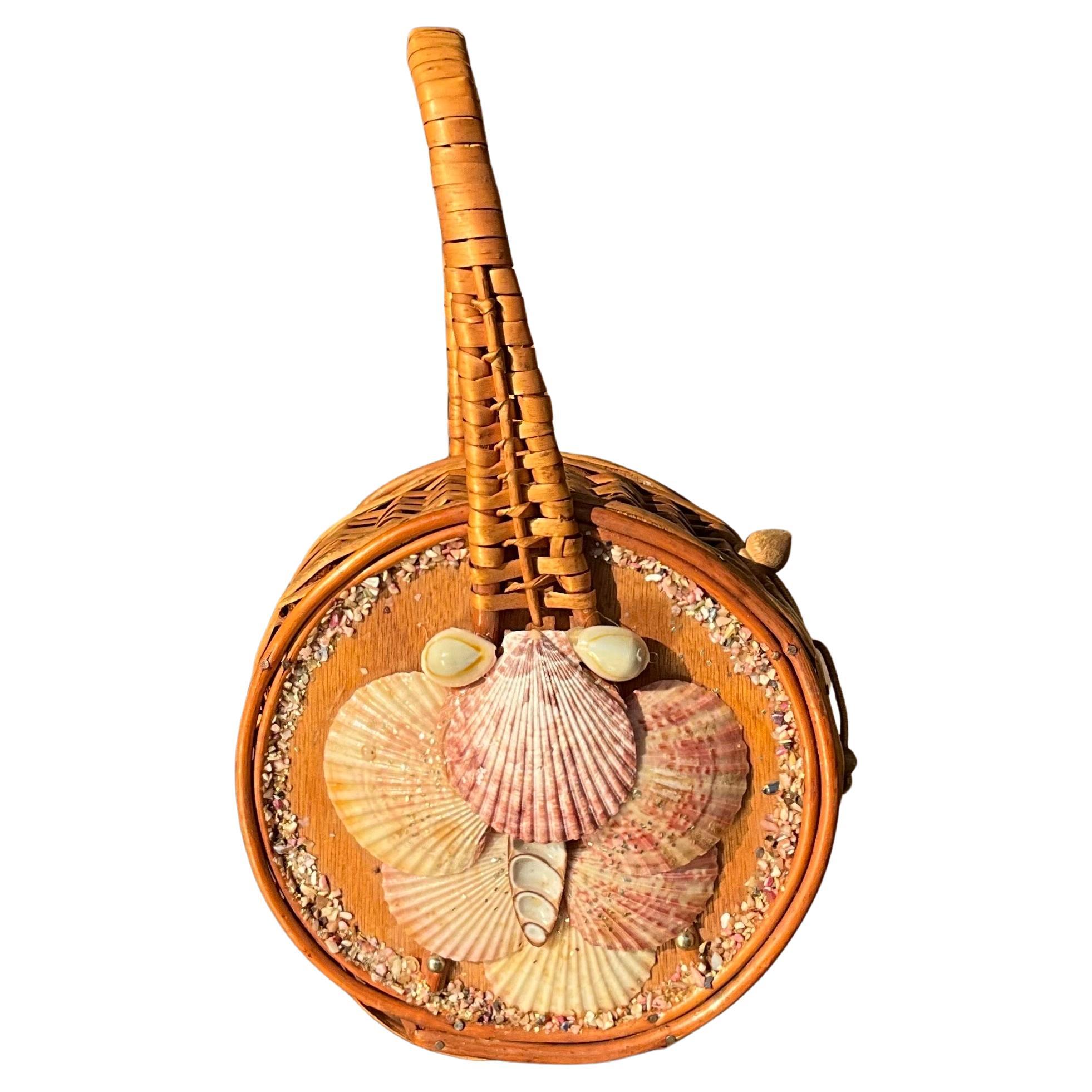 This Vintage Nantucket rattan basket bag with seashells is a unique and charming variation of the classic Nantucket basket, combining the traditional craftsmanship of woven rattan with decorative seashell embellishments. This style blends coastal