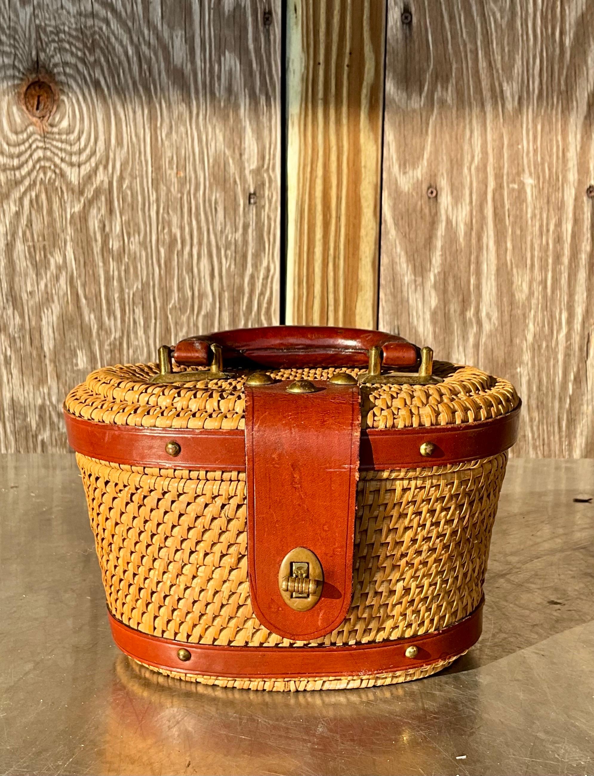 This vintage Nantucket rattan basket bucket bag is a handcrafted accessory that combines the elegance of Nantucket's artisanal tradition with a functional, stylish design. Nantucket, an island off the coast of Massachusetts, is known for its