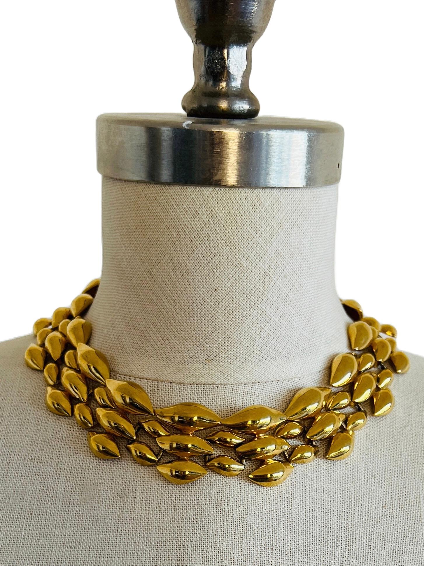 This stunning vintage Napier gold-plated choker necklace features a triple-strand design with teardrop-shaped links, creating a bold yet elegant statement piece. The secure fold-over clasp is marked with the Napier logo and patent number, showcasing