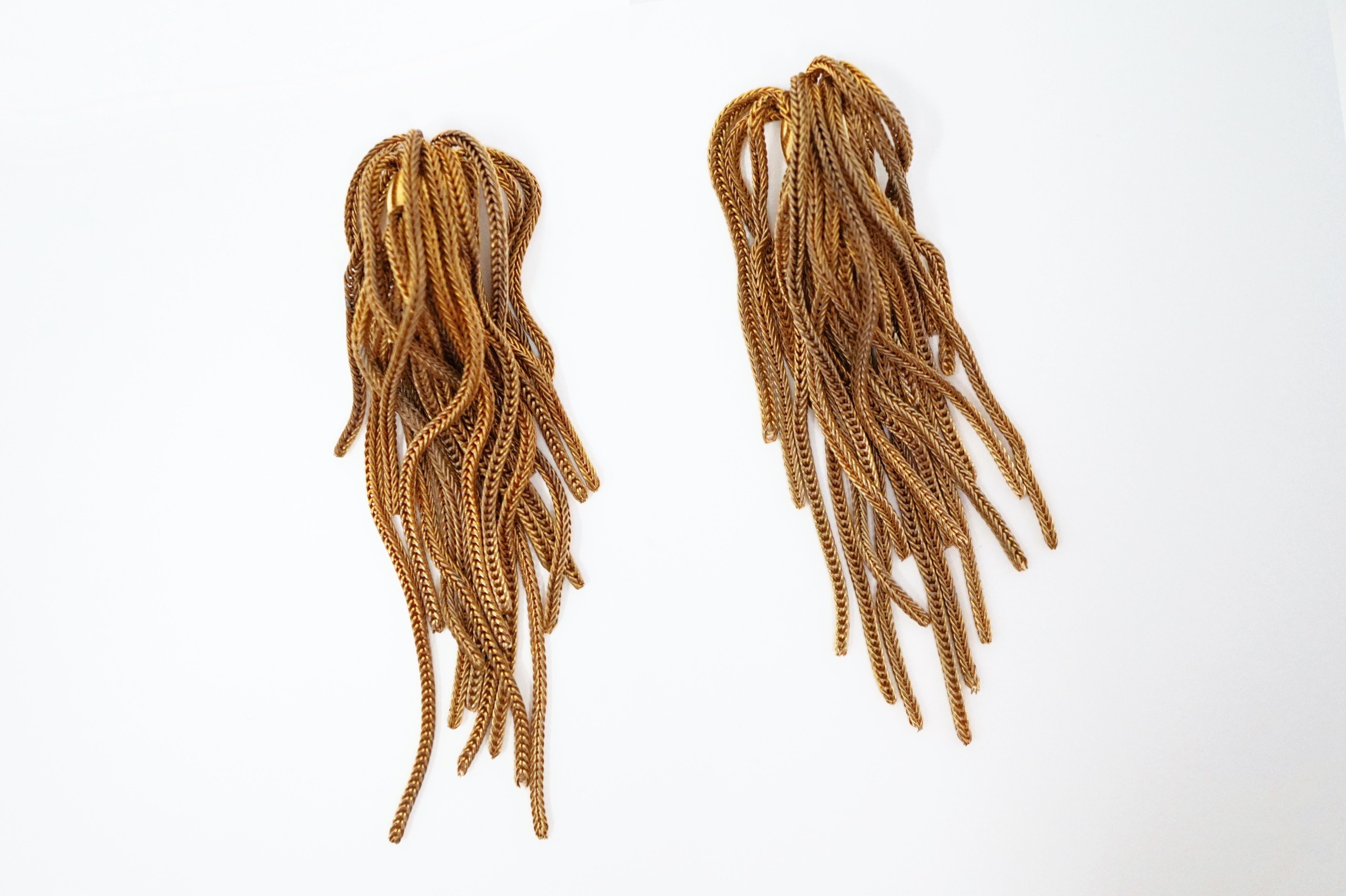 These gorgeous vintage Napier gold fringe clip-on earrings are a timeless accessory from the coveted costume jewelry brand. A single gold-plated bead holds a bundle of gold chain which cascades over itself for a seamless waterfall look. A wonderful