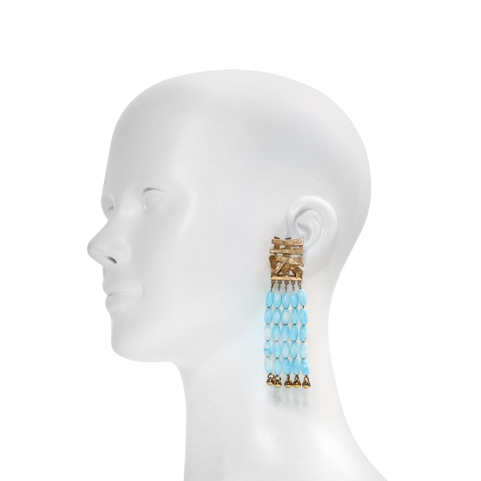 Vintage Napier Gold Tone with Faux Turquoise Dangling Beads. Four rows of dangling beads are attached to an Asian motif. Clip on.

This was a very sought-after collection and still is. They are stunning in person. They are substantial and