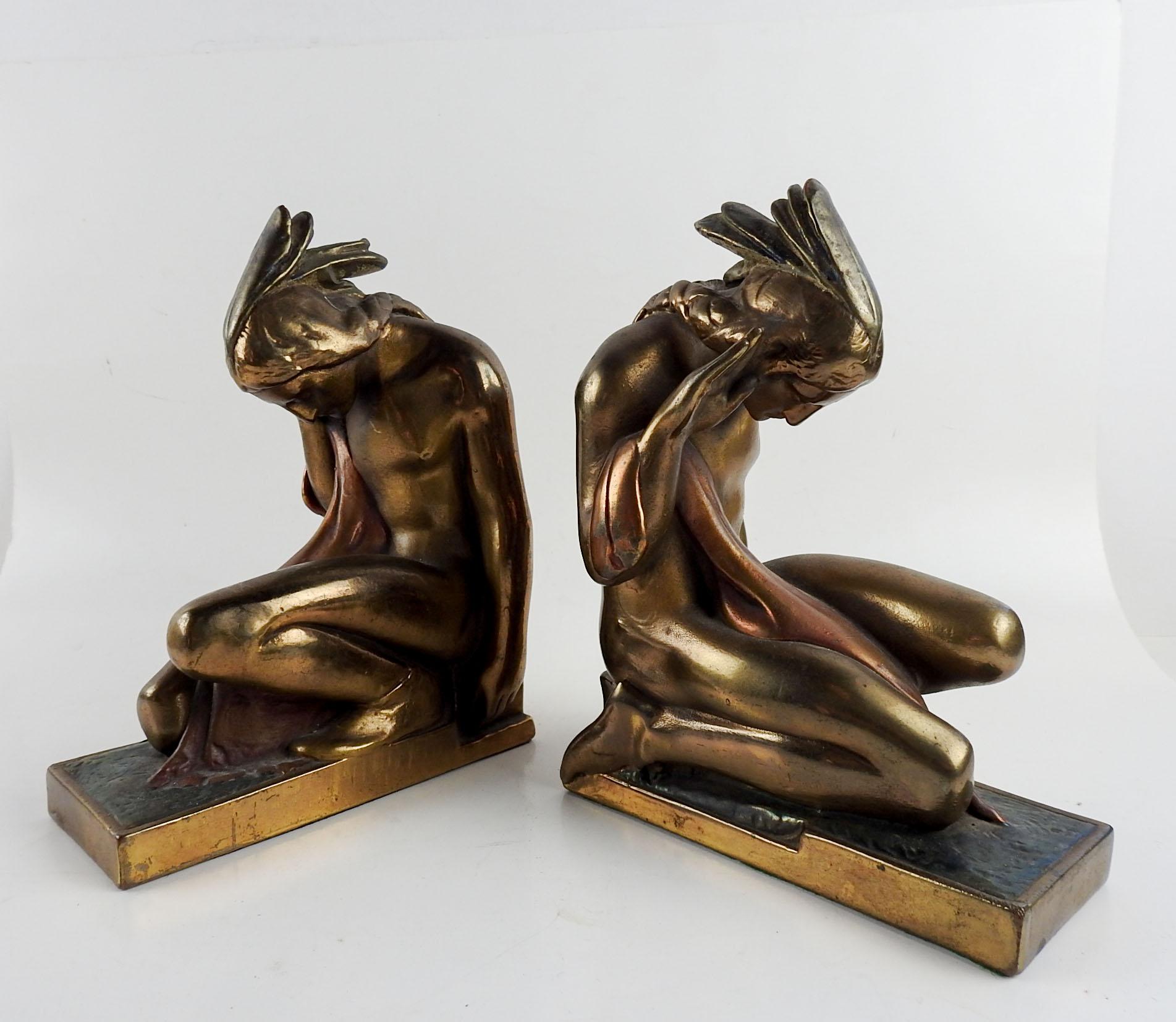 Circa 1920's vintage bronze plated metal bookends. Made by the Pompeian Bronze Company in New York, designed by Paul Herzel, with red coloring to blanket and irridecent blue to base.