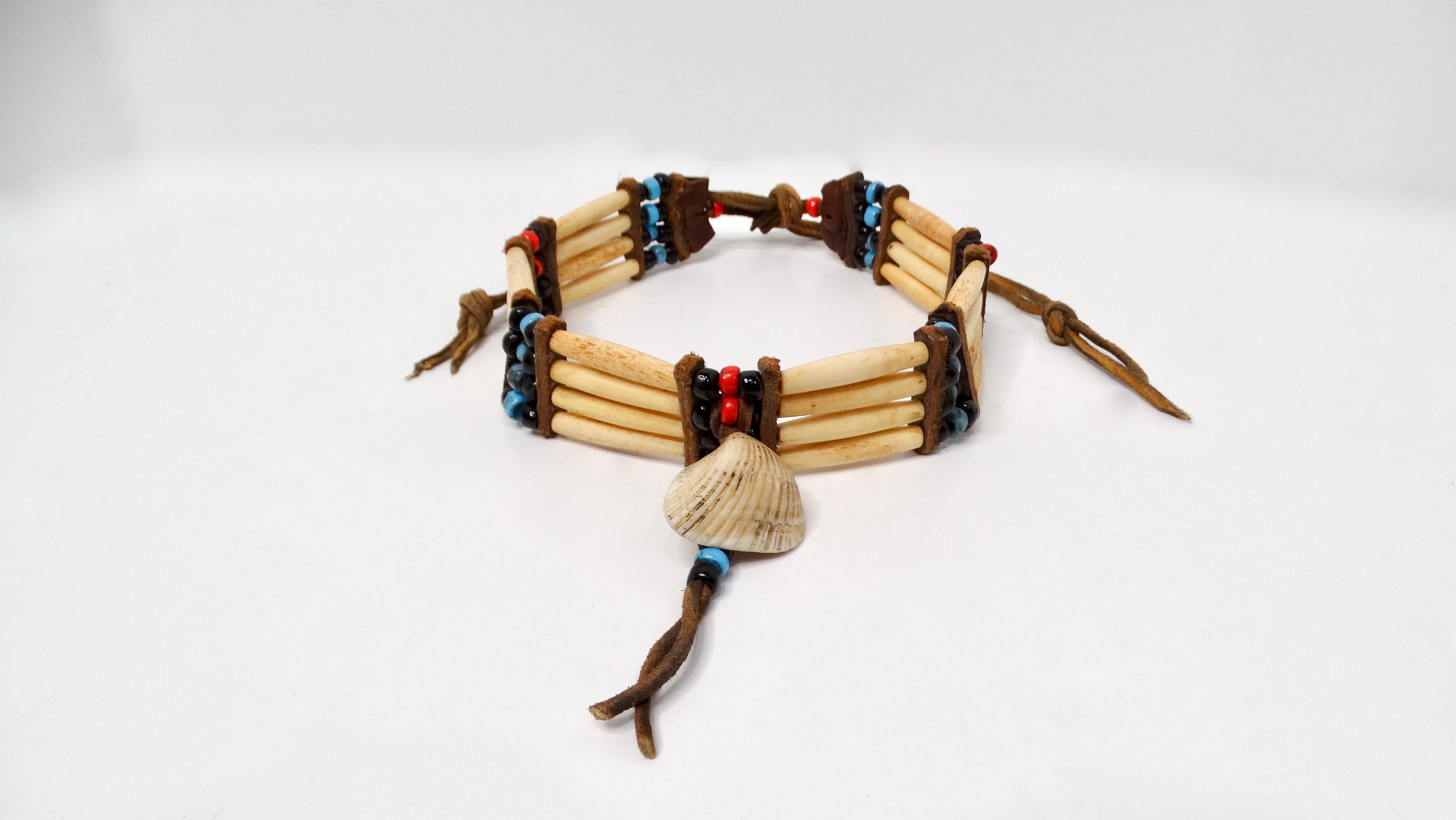 La collana vintage in osso di bufalo dei nativi americani è una splendida testimonianza dell'artigianato indigeno. Questo pezzo unico presenta un intricato disegno con perline blu, nere e rosse, armoniosamente combinate con perline in osso di bufalo