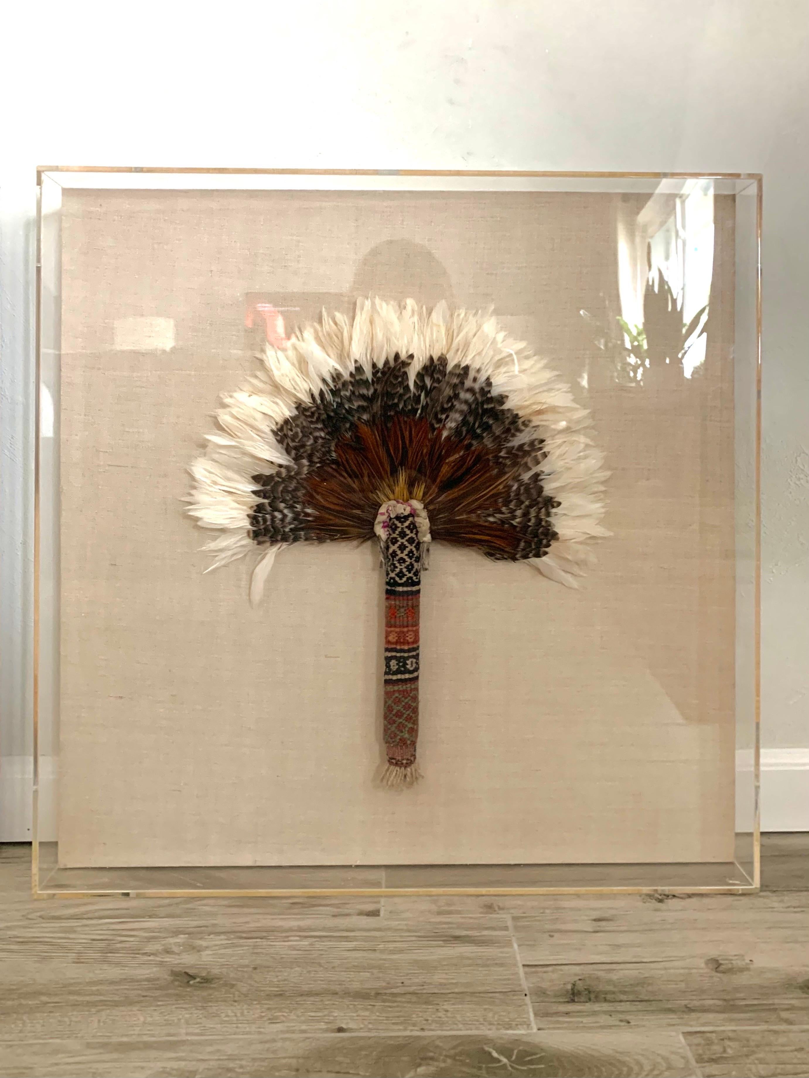 Fantastic pair Native American fans made from feathers and woven materials. Beautifully hand crafted and designed to make exceptional art pieces. The fans are displayed and mounted in the center of a lucite box on a natural linen covered board.