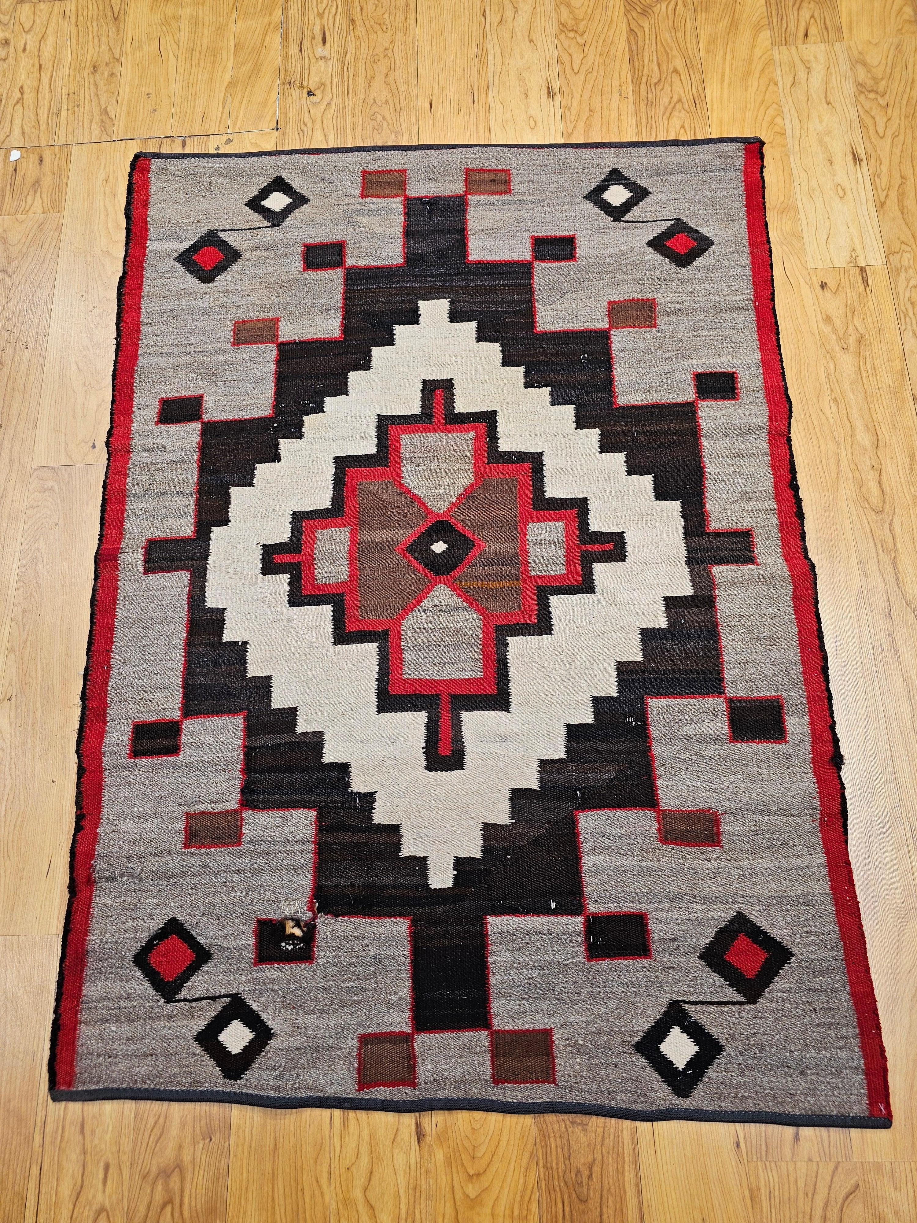 Beautifully preserved early 20th-century Navajo area rug, handwoven in the American Southwest, this piece is a striking example of traditional Navajo craftsmanship. The rug features a bold central medallion design, framed within a harmonious palette