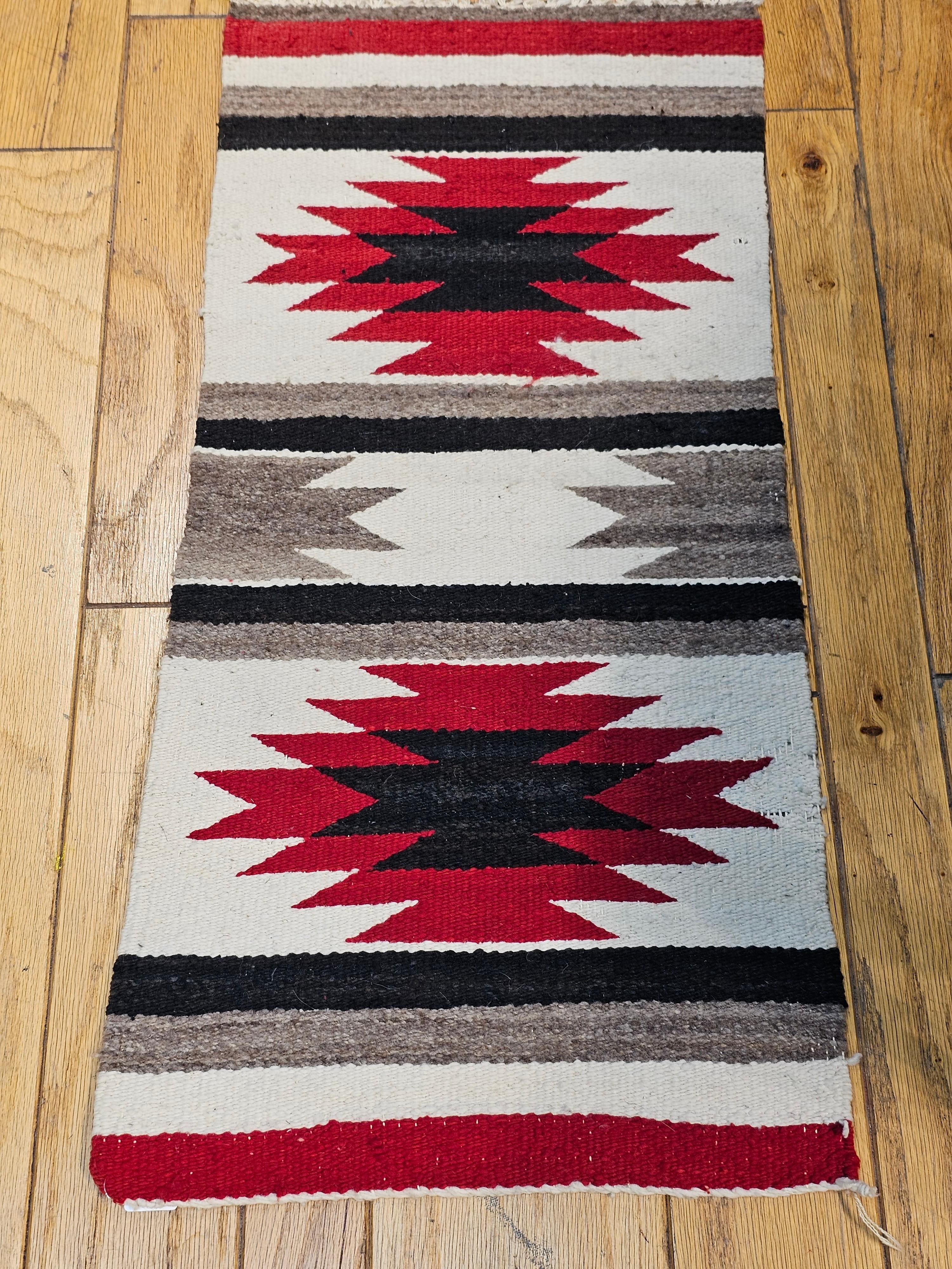  Vintage Native American Navajo area rug in a double medallion pattern in ivory, red, black, and gray.  Navajo rugs are generally flat woven with wool for the body of the rug and usually cotton foundation.  Navajo weavers usually try to use natural