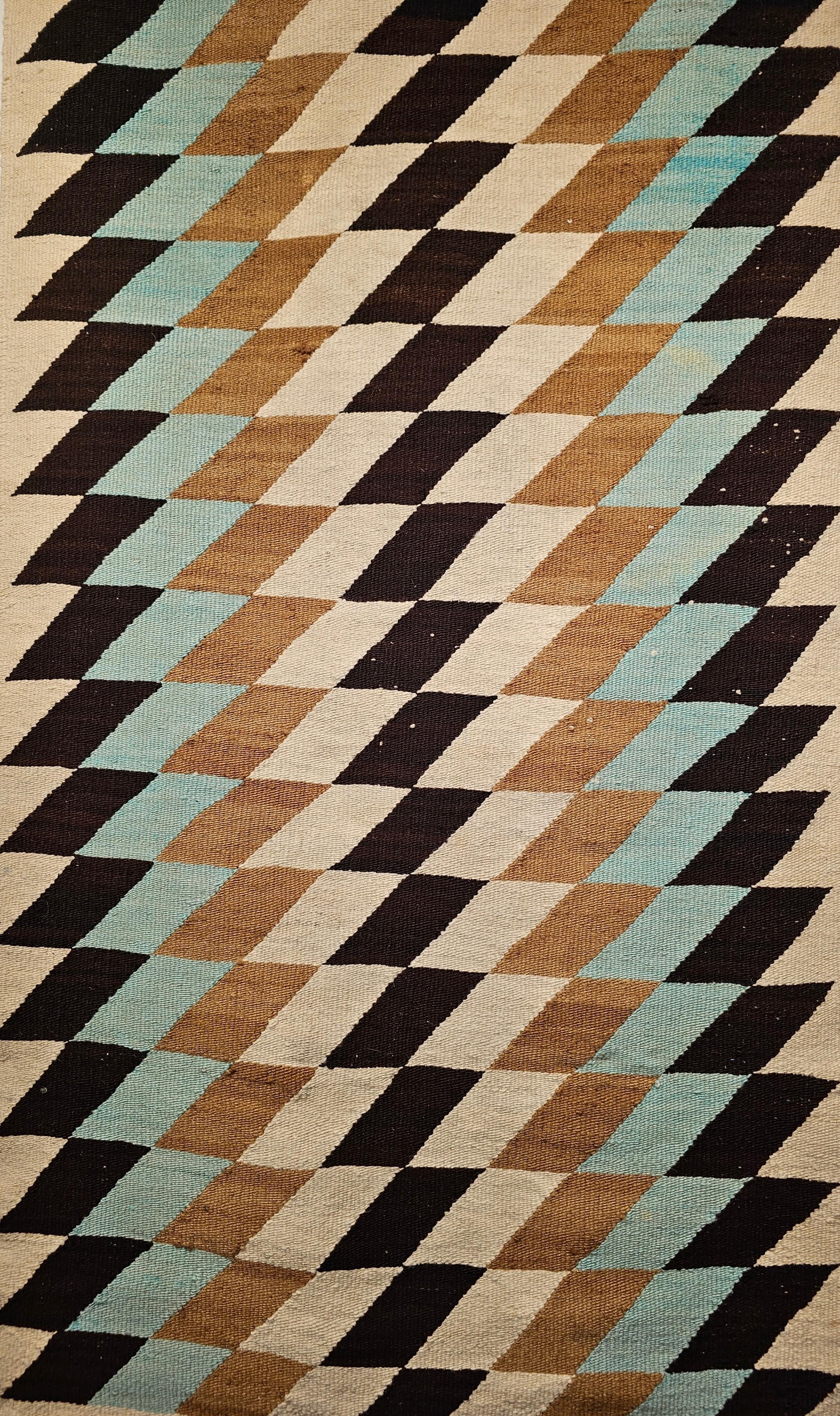 Vintage Native American Navajo rug is in a block pattern from the mid 1900s. The natural colors in this Navajo rug are in beautiful earth tones including turquoise blue, black, ivory, and brown, black, and gray. Navajo weavers use natural organic