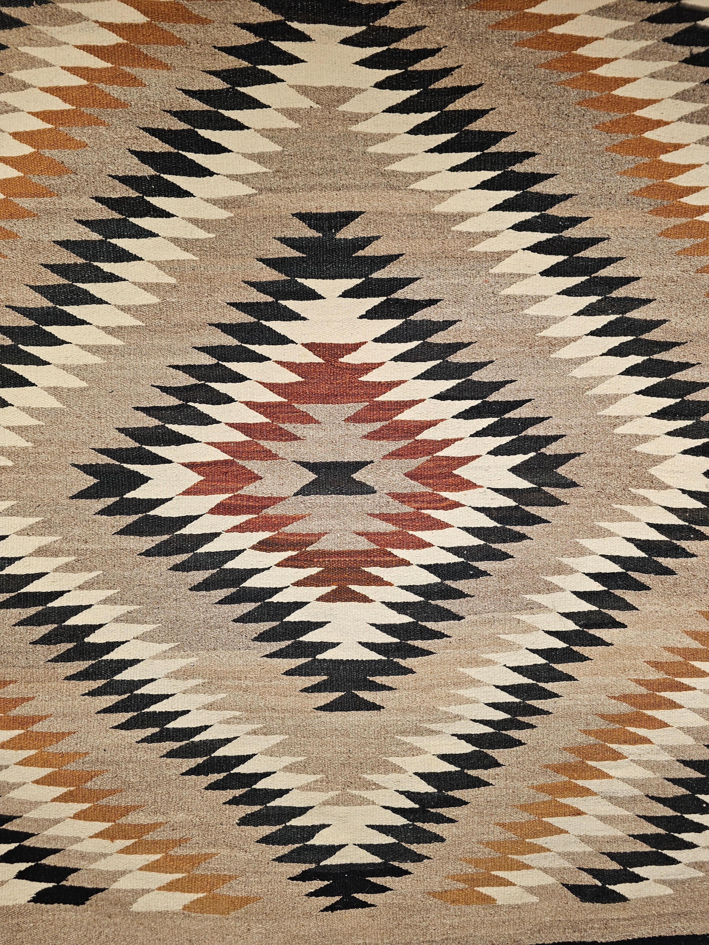 Vintage Native American Navajo rug is in an “Eye Dazzler” pattern from the mid 1900s. The natural colors in this Navajo rug are in beautiful earth tones including brown, black, and grey. Navajo weavers use natural organic dyes that are available