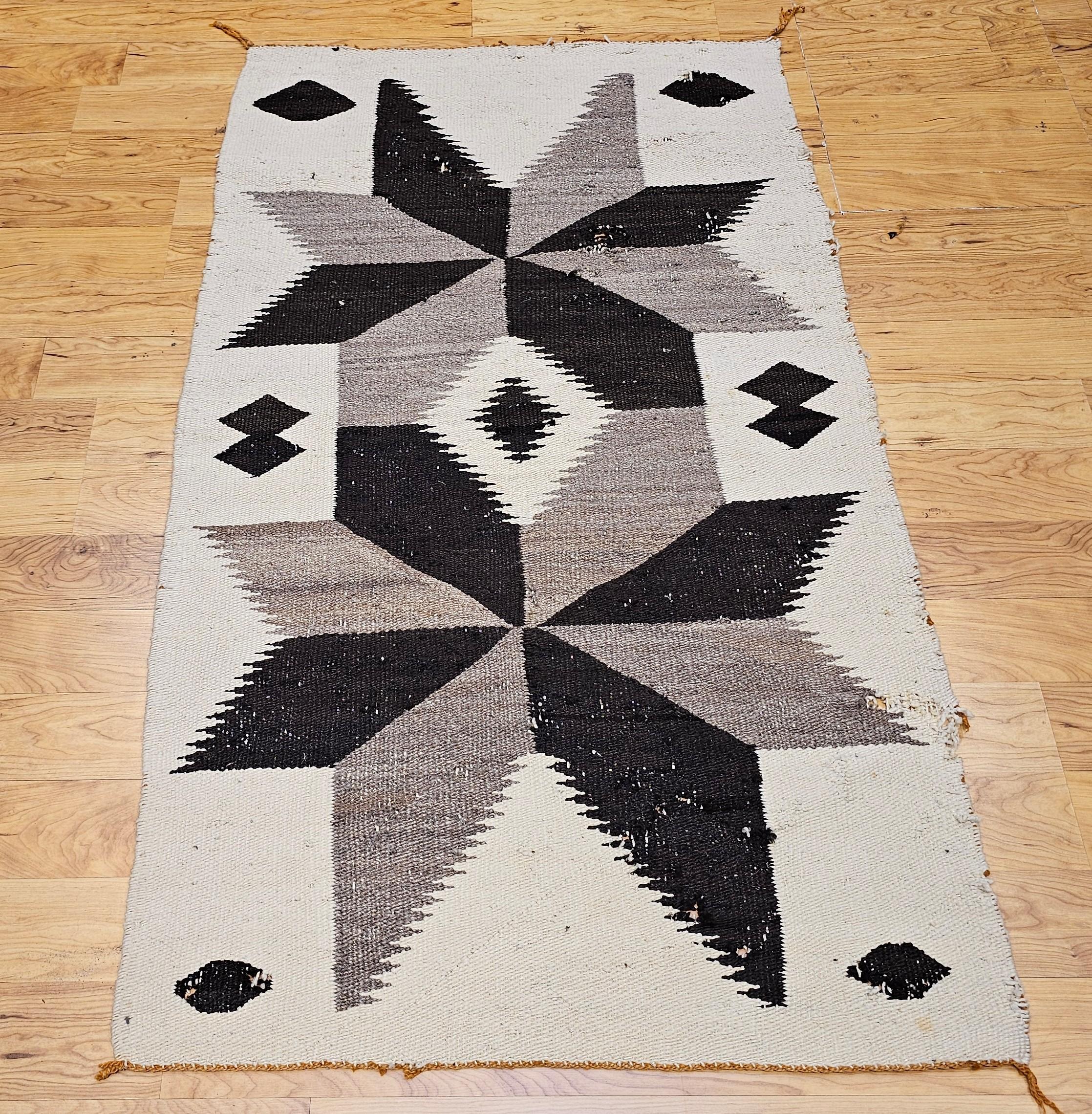 Ce tapis Navajo vintage, tissé à la main au milieu du XXe siècle, présente un caractère intemporel et une richesse culturelle. Il se caractérise par une palette douce et terreuse d'ivoire, de gris et de marron. Avec sa texture légèrement usée et son