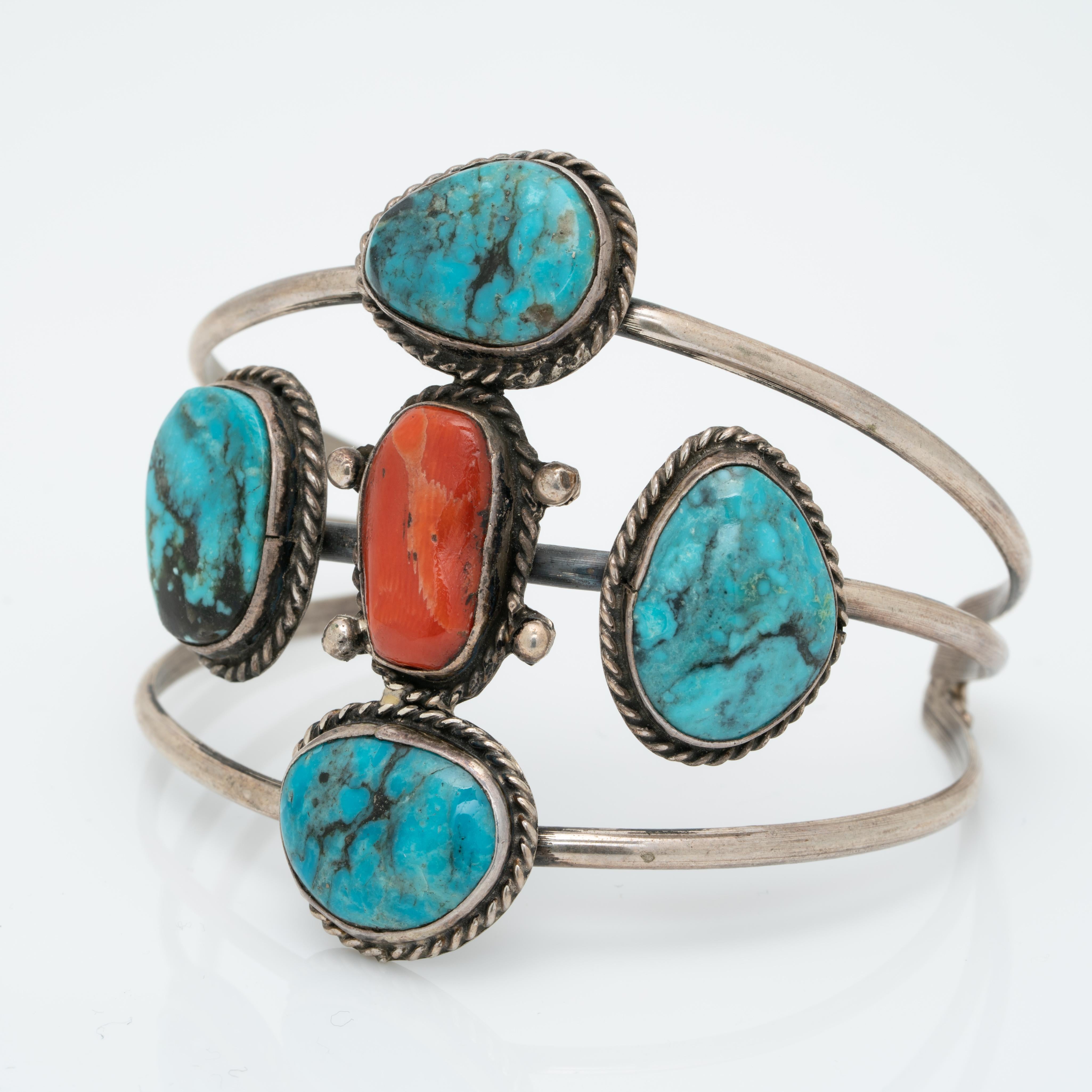 Vintage Native American Navajo Sterling Silver and Turquoise and Coral Bracelet Cuff c.1970s

Hand forged. A wonderful vintage Navajo cuff!

The patina of the silver is oxidized, we do not clean vintage and antique silver pieces as some clients