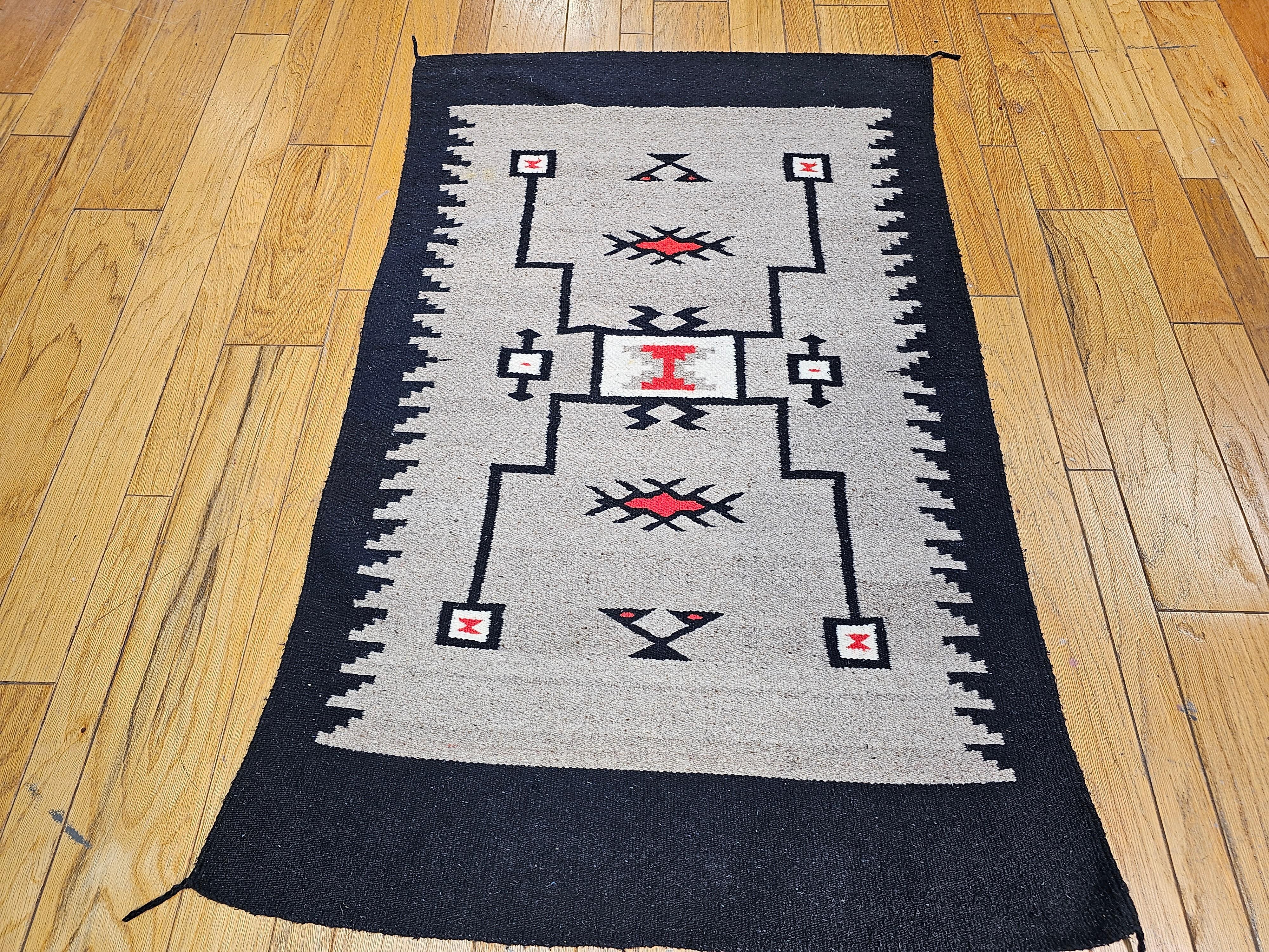Vintage Native American Navajo rug in a Storm Warrior pattern in gray, Ivory, red, and black handwoven in the SW United States. Circa the 1920-1930. This rug has a very unique and wonderful color combination including gray, black and ivory. The rug