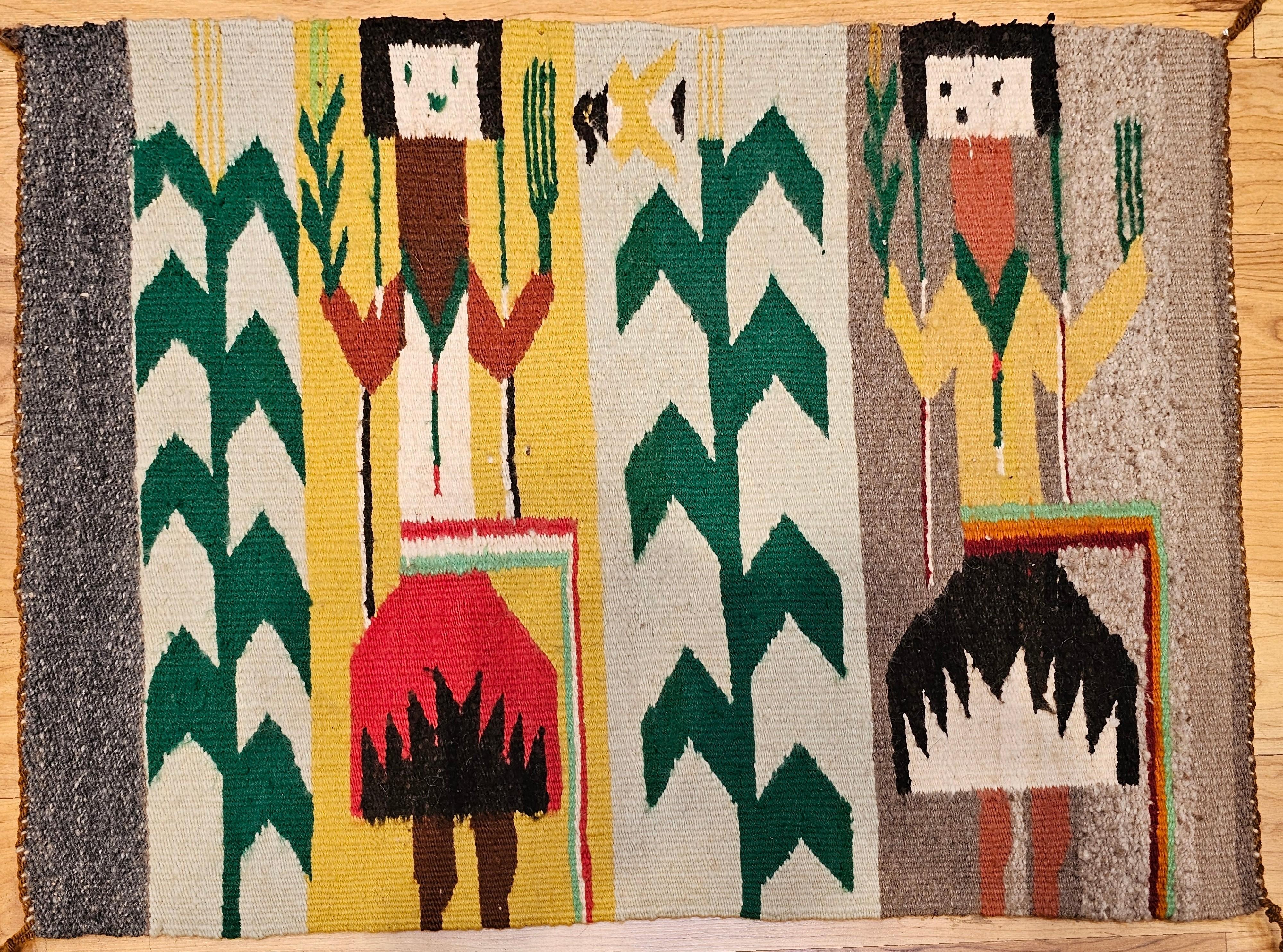 Vintage Native American Navajo Yei rug from the 3rd quarter of the 1900s.  The design of this Navajo Yei contains two deity forms standing with corn stalks next to each. In Navajo mythology, the Yei are a group of deities who act as mediators