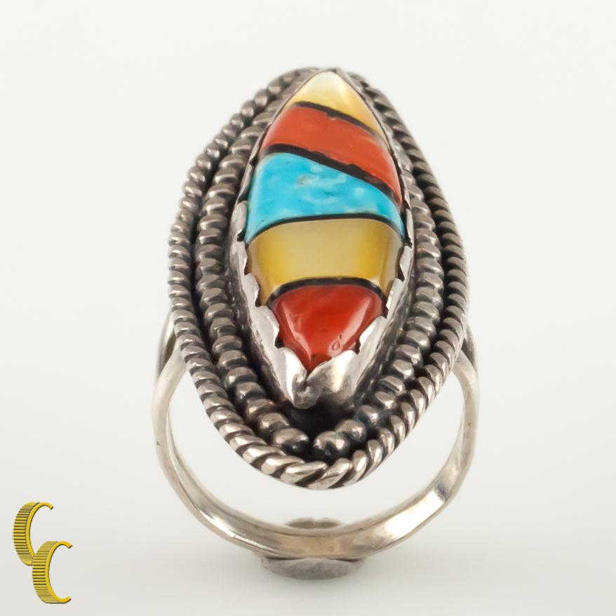 Gorgeous silver ring with a lapidary inlay plaque.
Features shell, onyx, coral and turquoise.
Size: 6.5.
Length of Plaque: 51 mm.
Metal: 0.925 sterling silver.
Weight: 10.8 grams.