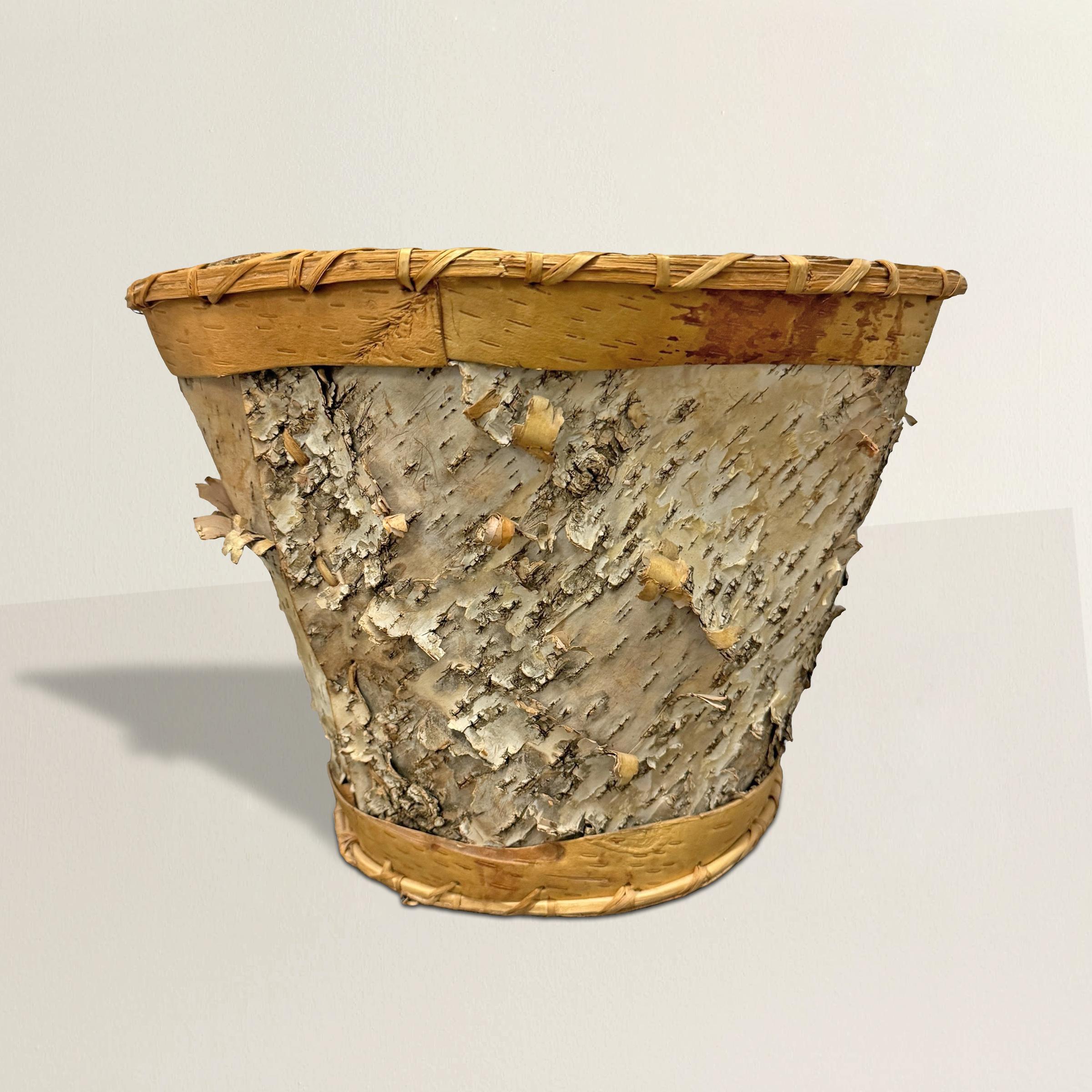 Questo cesto di bacche vintage dei nativi Chippewa è un bellissimo esempio di artigianato tradizionale, realizzato interamente con corteccia di betulla. La corteccia bianca, ruvida e strutturata, forma i robusti lati del cesto, mettendo in evidenza