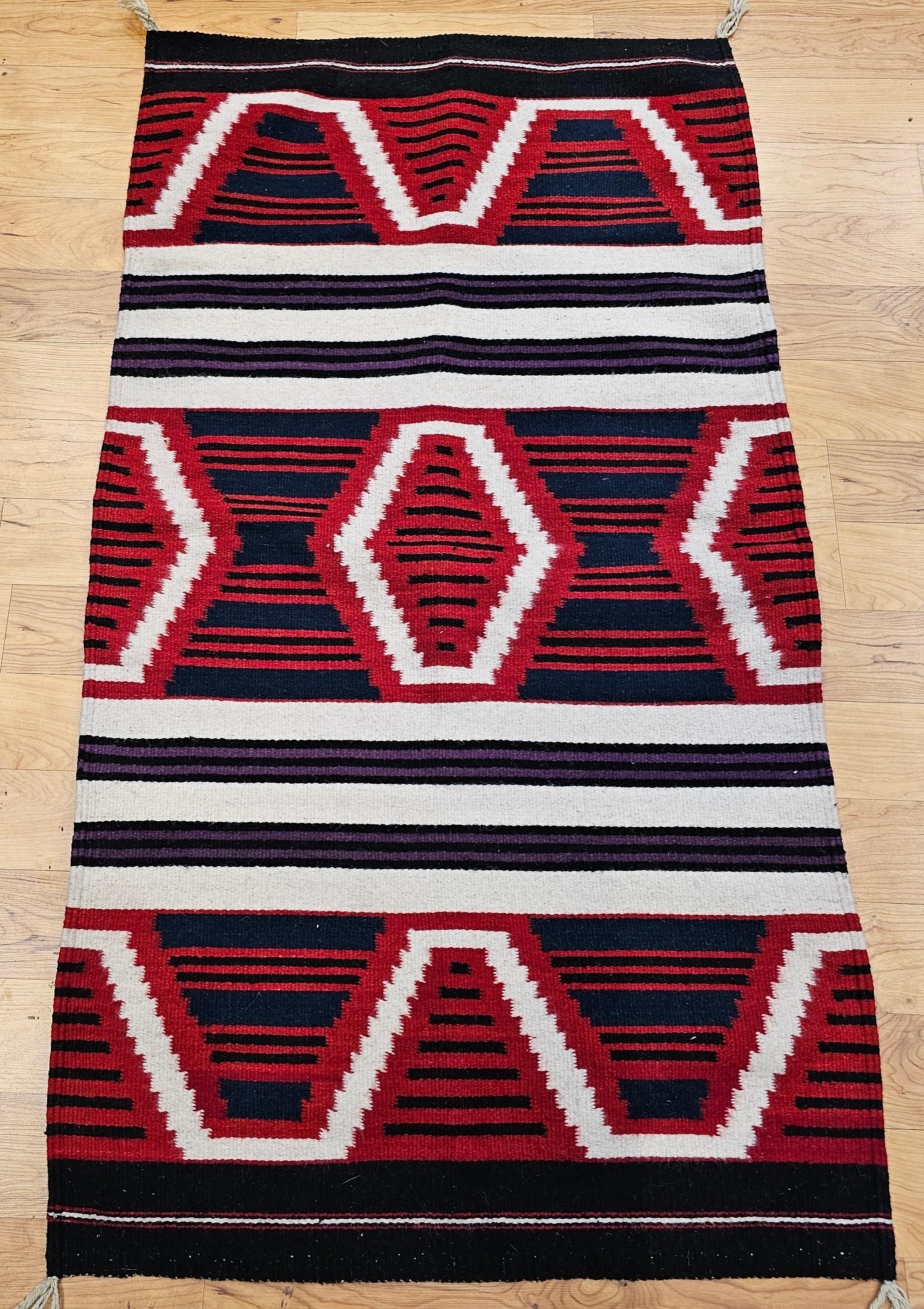 Esta alfombra vintage de los indios navajos, tejida a mediados del siglo XIX, presenta el icónico dibujo de la manta del jefe, un diseño audaz y culturalmente significativo dentro de la tradición de tejido navajo. Realizado en una rica paleta de