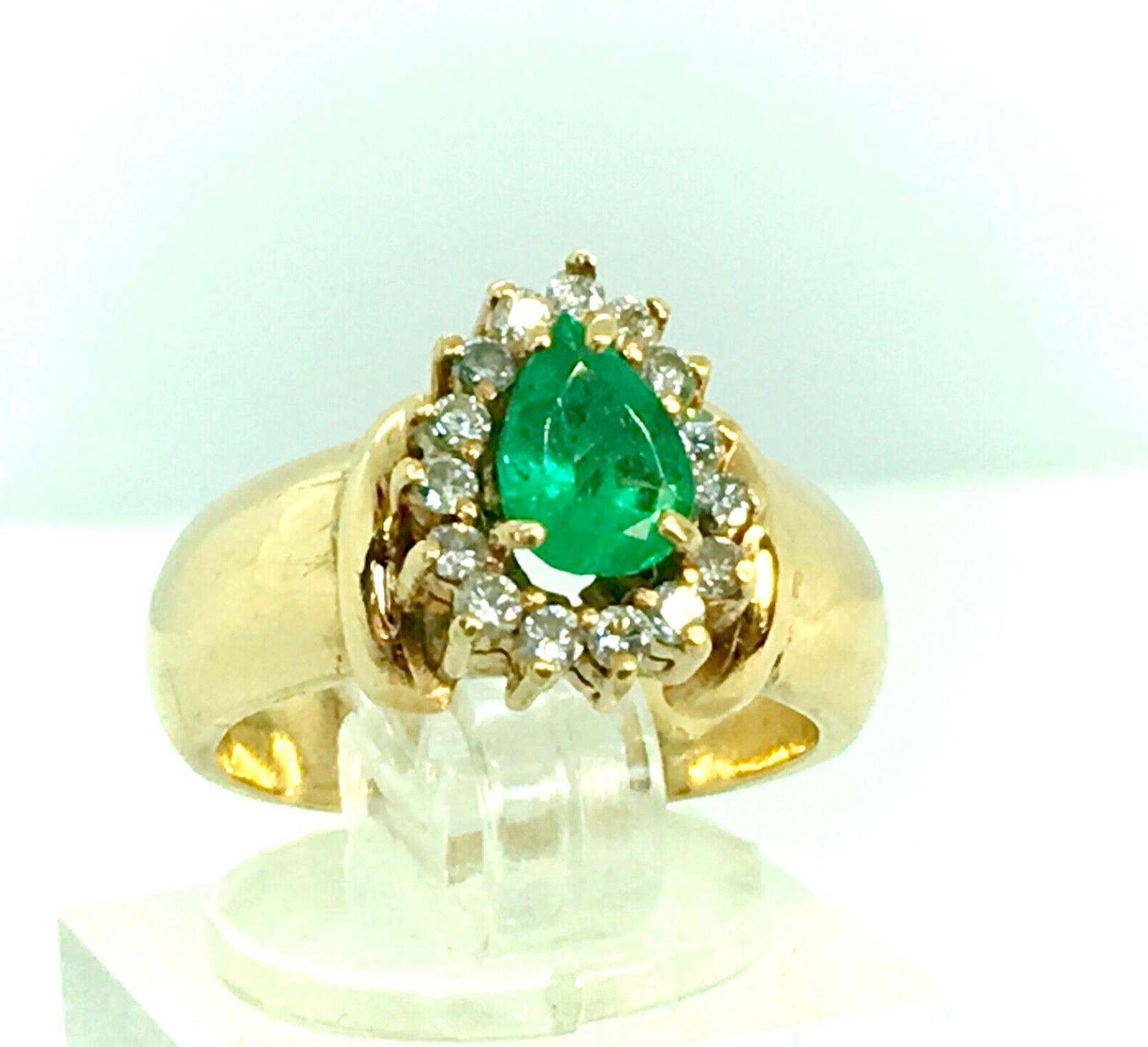        
A Vintage Natural Colombian Emerald and Diamonds Ring Solid 18K Yellow Gold
Centered with a Natural Colombian Emerald Pear Cut, weighing approx. 1.10 Carat, Vivid Medium Green. Surrounded by 14 round Diamonds weigh Approx 0.50ct
Color