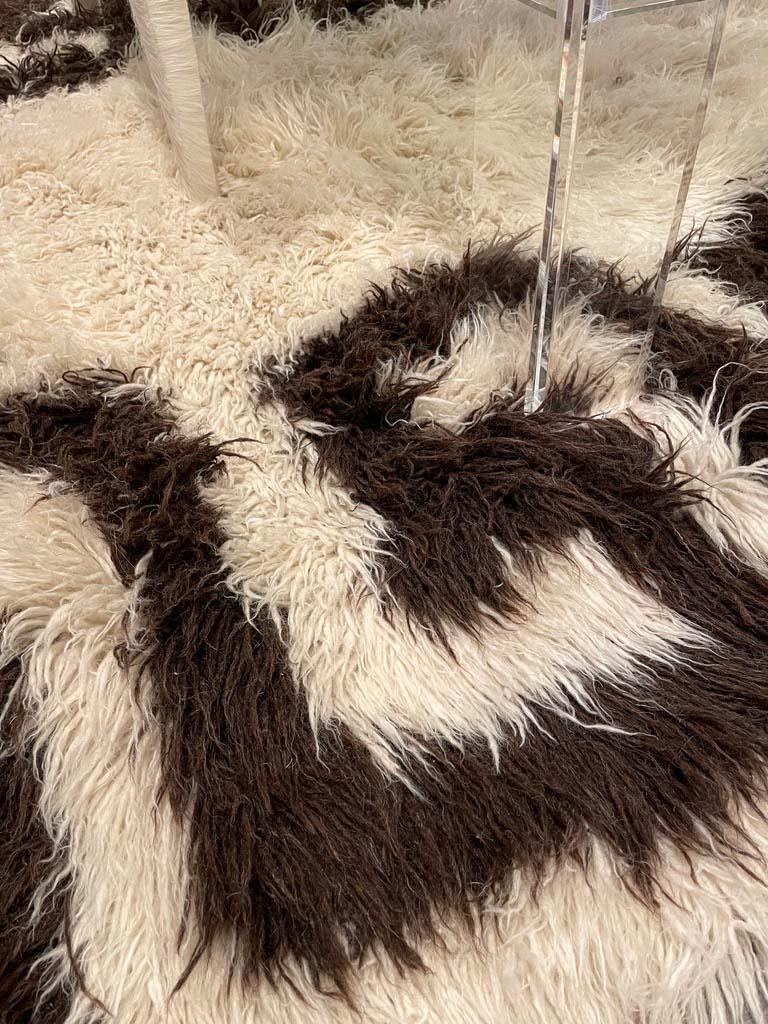 Beautiful vintage natural fur flokati rug. the hair is long and the greek key is very striking. the rug has been cleaned and in good shape.