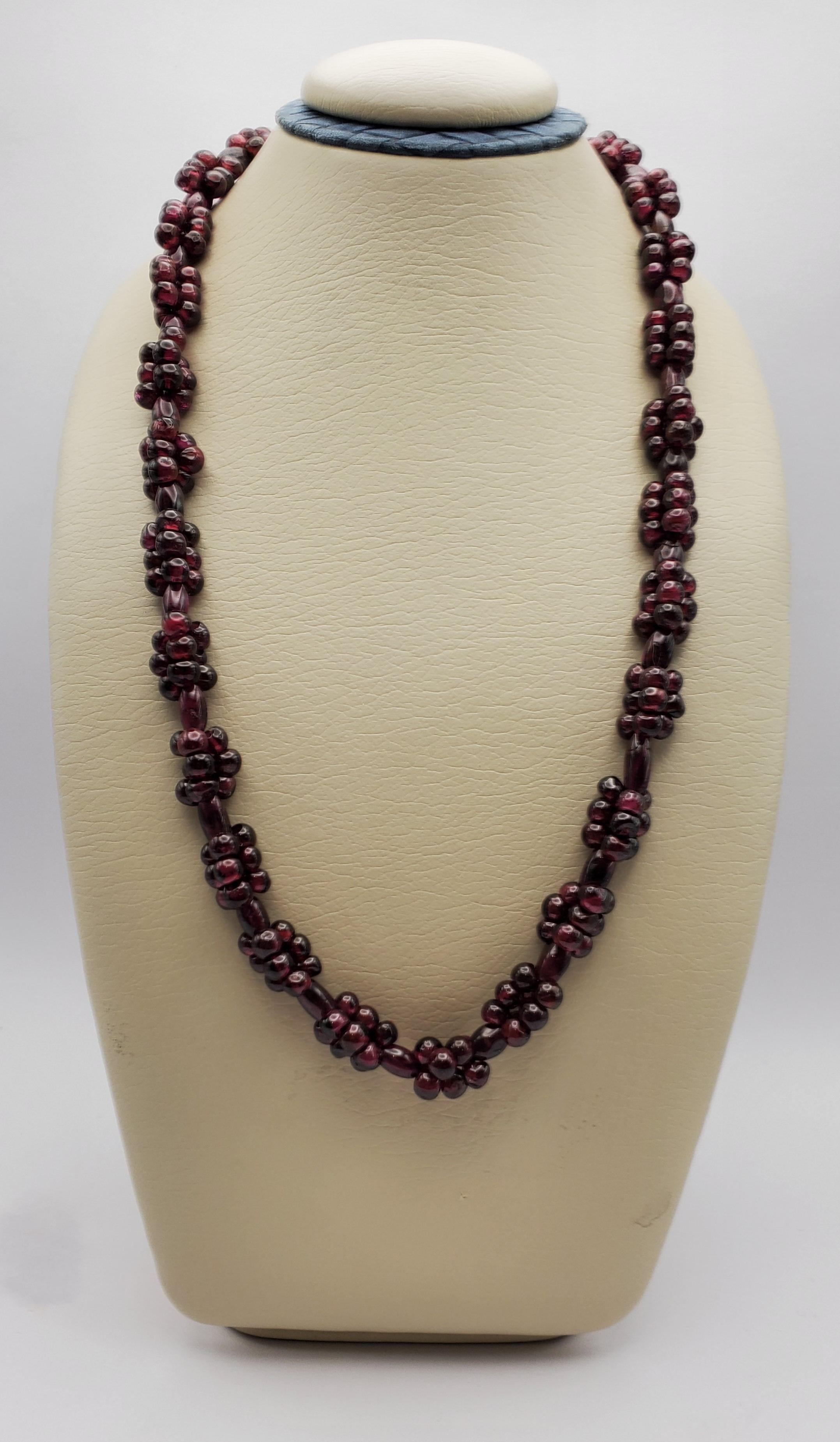 Beautiful polished garnet bead cluster station continuous necklace from the 1970s. The beads have the rich color of red grapes and shine in appealing bunches, adding interesting texture to this strand. The necklace does not have a clasp but at 24