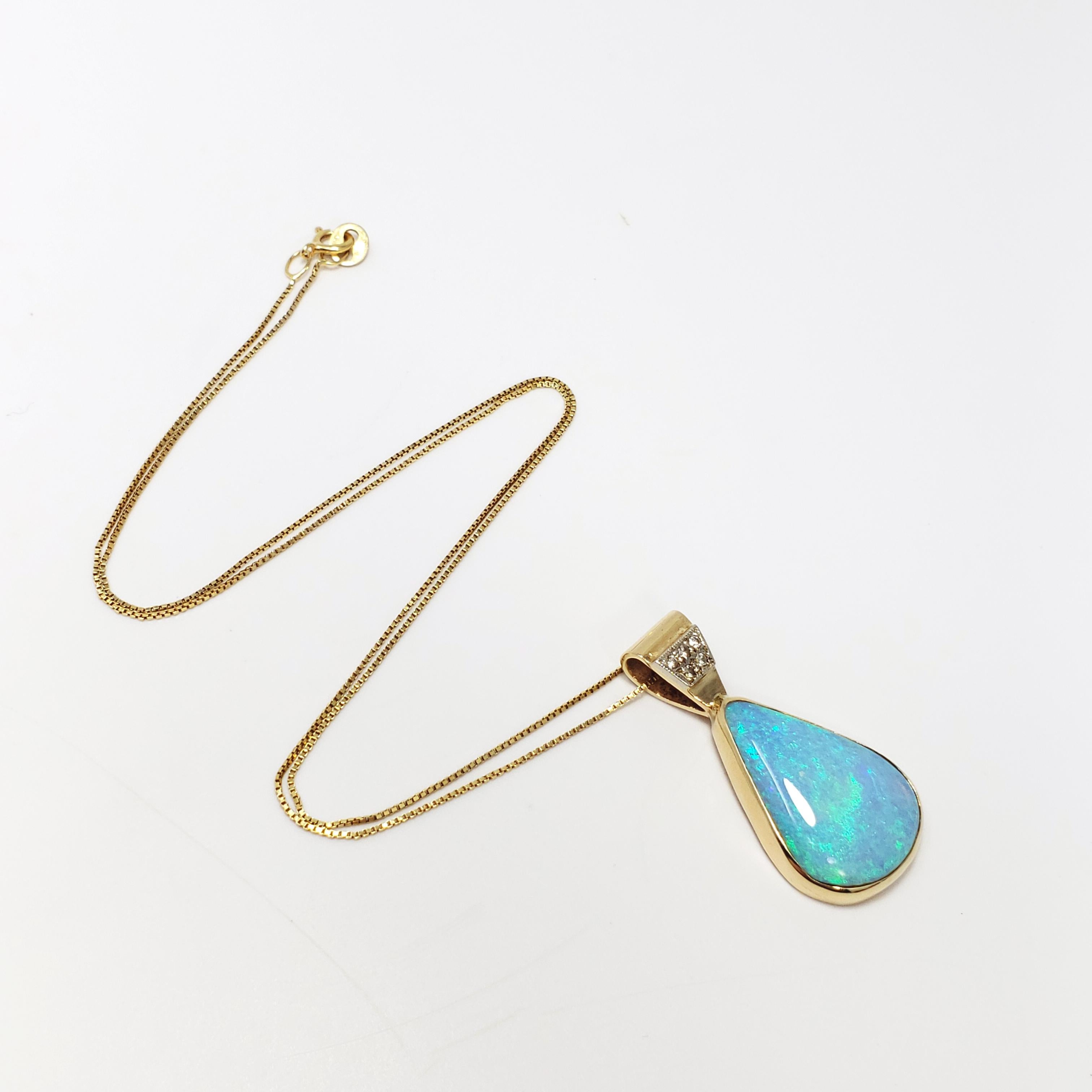 This gorgeous pendant features a natural tear-drop shaped opal in glowing blue and teal colors, set in a 14KT gold bezel, accented with 6 diamonds set in platinum. Hangs off a fine Italian 14KT gold chain. An excellent touch to any casual or formal