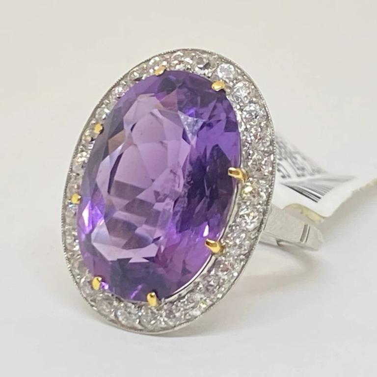 Natural oval faceted purple amethyst set in yellow gold prongs with an old European cut diamond halo surrounding the center. Designed in platinum with accents of 18 karat yellow gold. 

Center: Natural Amethyst
Shape: Oval Brilliant
Weight: 12