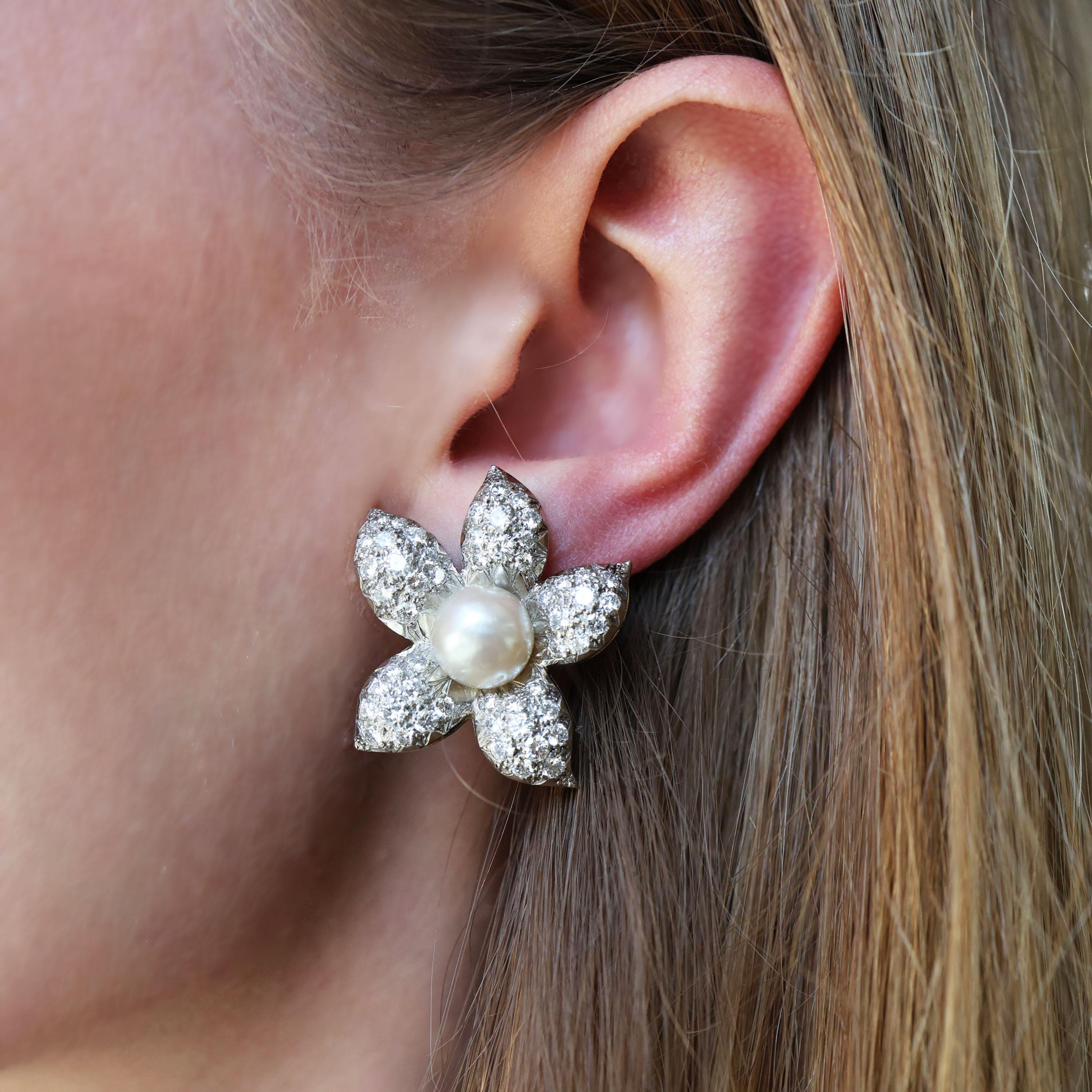 Un paio di orecchini a clip vintage con perle e diamanti, con una perla naturale bouton incastonata in ciascun centro del fiore, i petali con pavé di diamanti rotondi taglio brillante, montati in platino su oro, circa 1950, accompagnati dal
